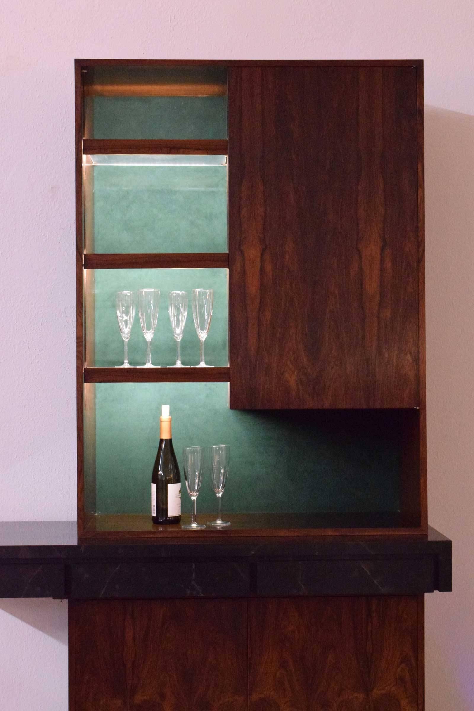Beautiful rosewood veneer, faux marble top, felt lined drawers, lucite shelves with rosewood trim, lighting on top and bottom, wine storage.