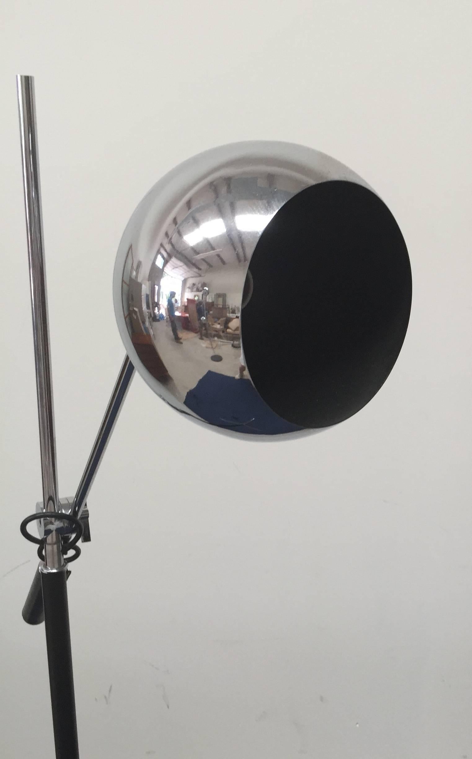 Classic single arm chrome orbiter tripod floor lamp. Excellent vintage condition, original cord and leather wrapped handle, with fully adjustable and articulating head. Chrome is free from pitting or peeling. Measures: 57.75