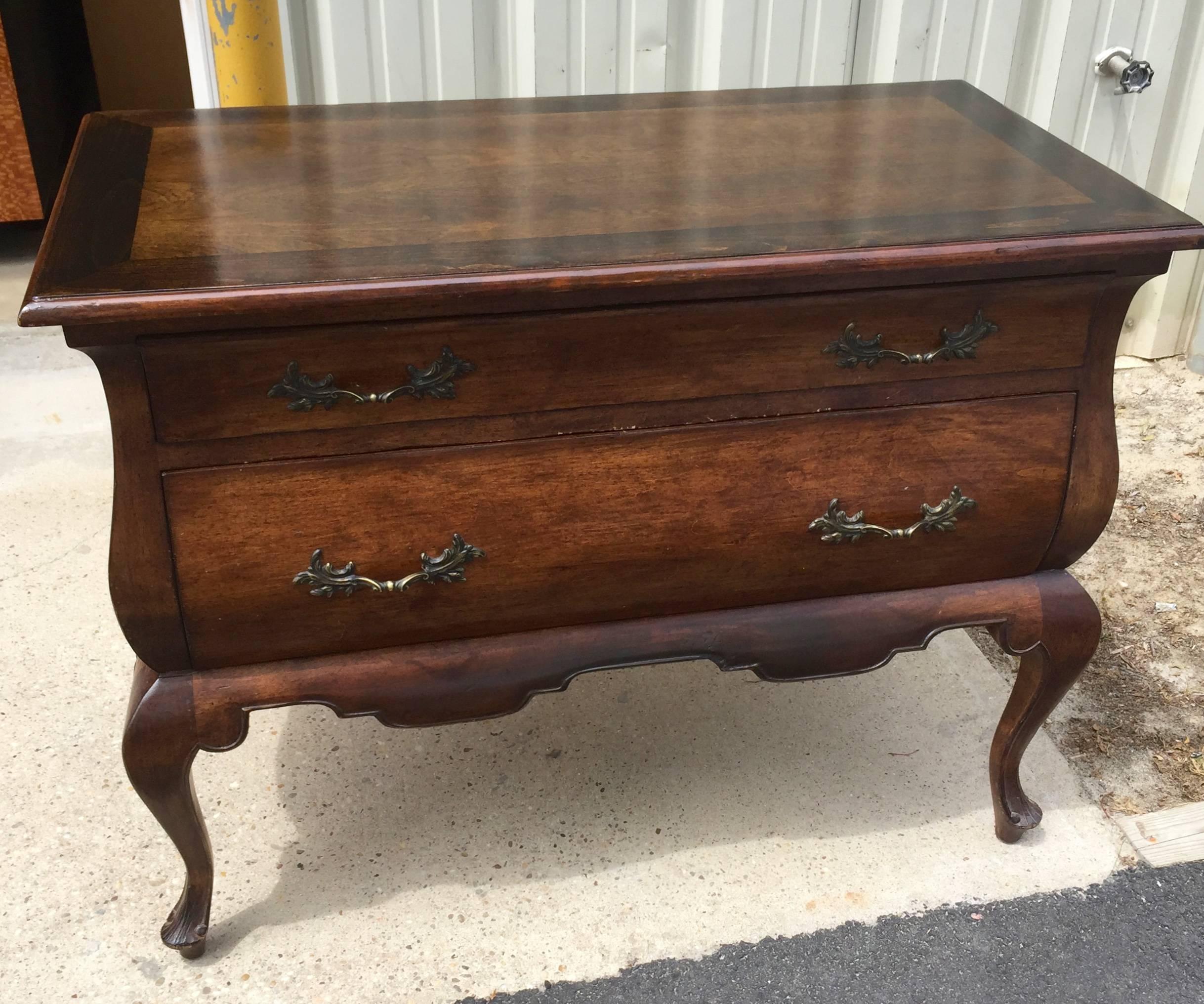 Decorative and functional, this pair of cabinets would work well as sofa end tables or as nightstands. They are walnut with a banded top in a darker inlay.