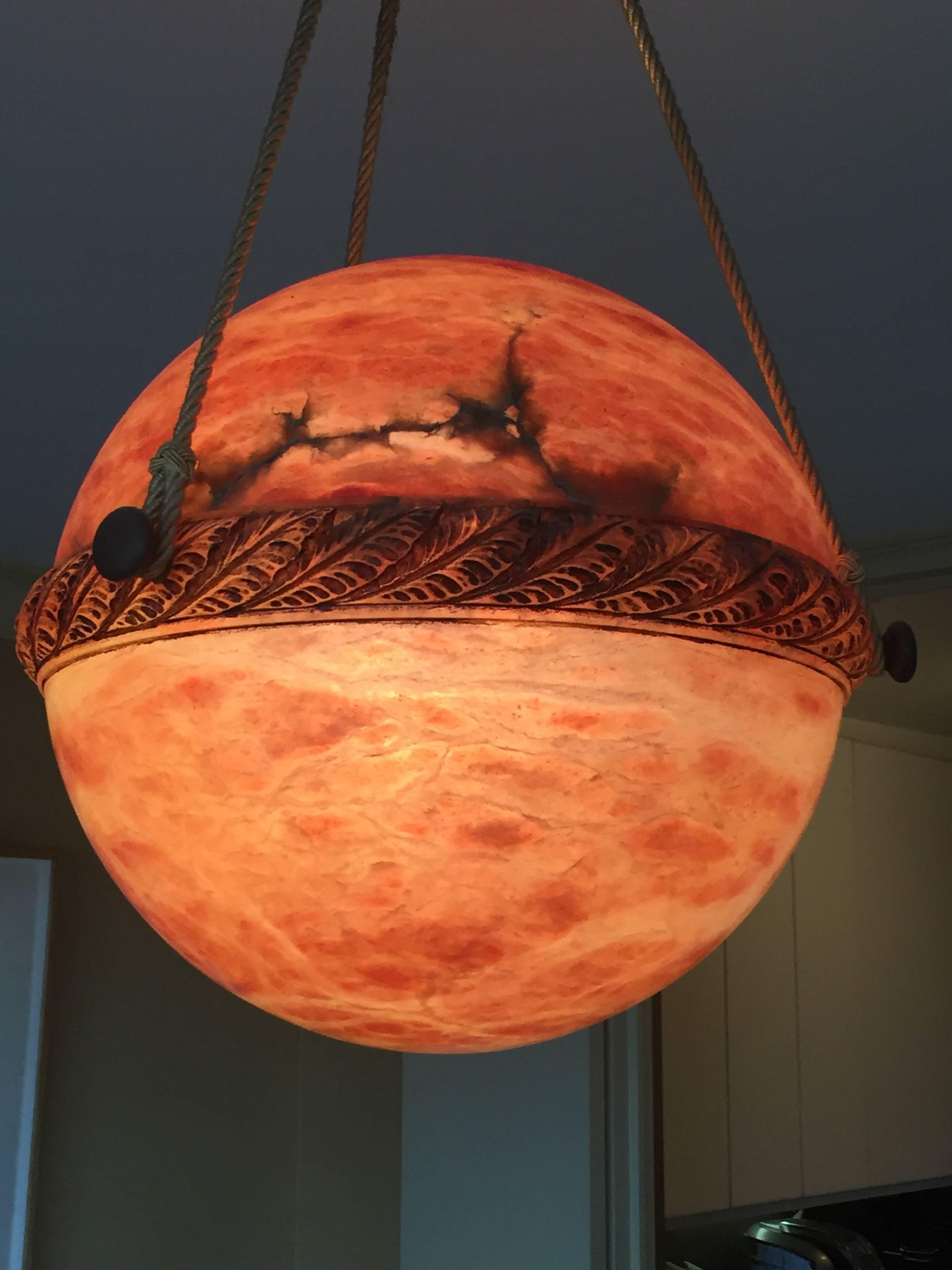 Antique 1920s style amber colored alabaster chandelier.
Matching alabaster ceiling cap with silk covered cording for the suspension.
Handcrafted in Sweden with handsome carving and simple details.