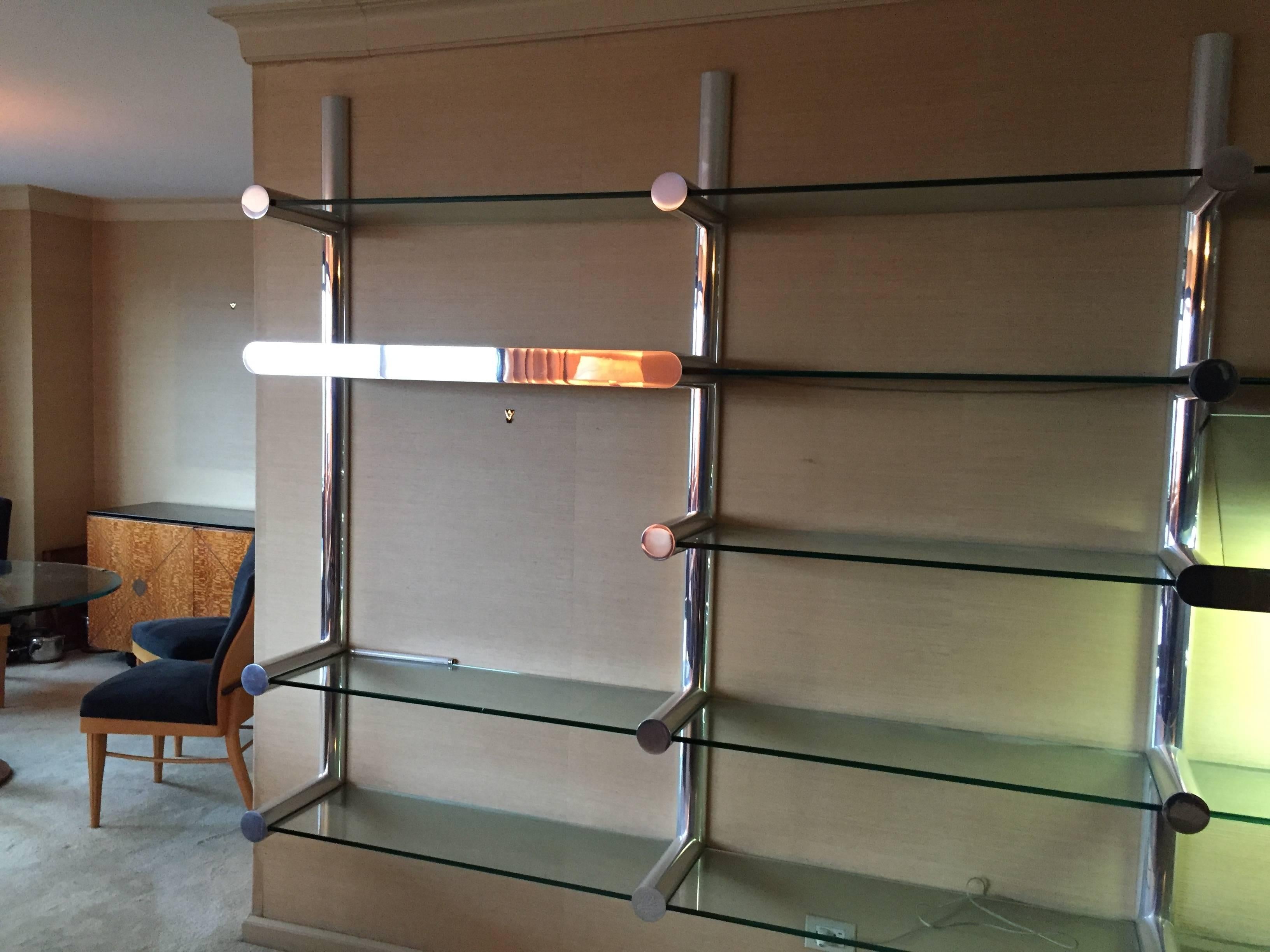 Orba Wall System designed by Janet Schwietzer for the Pace Collection, NY. This system consists of 3 bays with 14 glass shelves held in place by four vertical wall mounted uprights and includes 2 lighted units all constructed and finished in