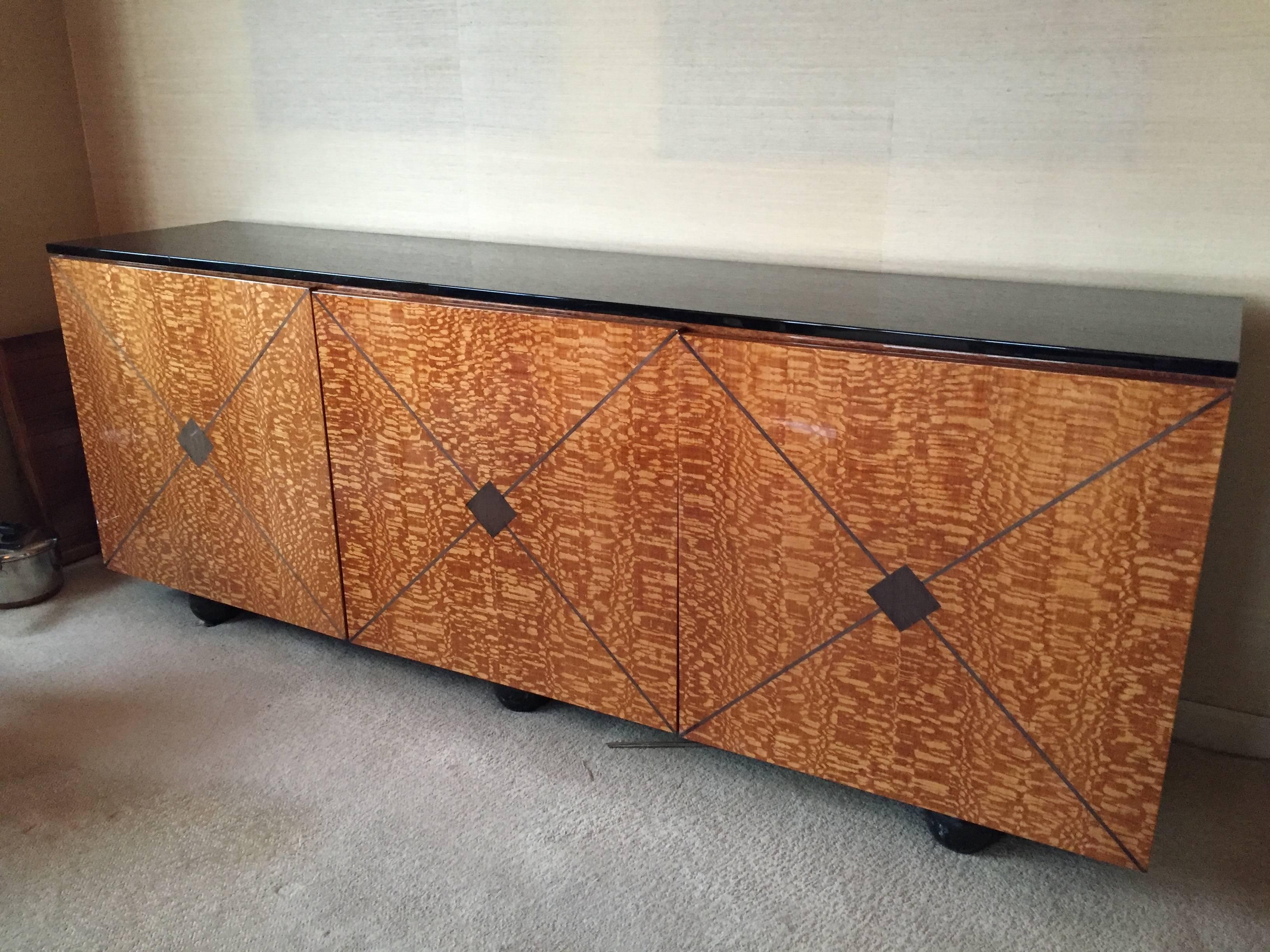 Sideboard / Server in black lacquered and exotic veneered wood front with a highly gloss finish. Done by Roche Bobois in early 1970's with one owner only. 
Very good condition to excellent condition (old repair to one hinge as pictured)
Interior