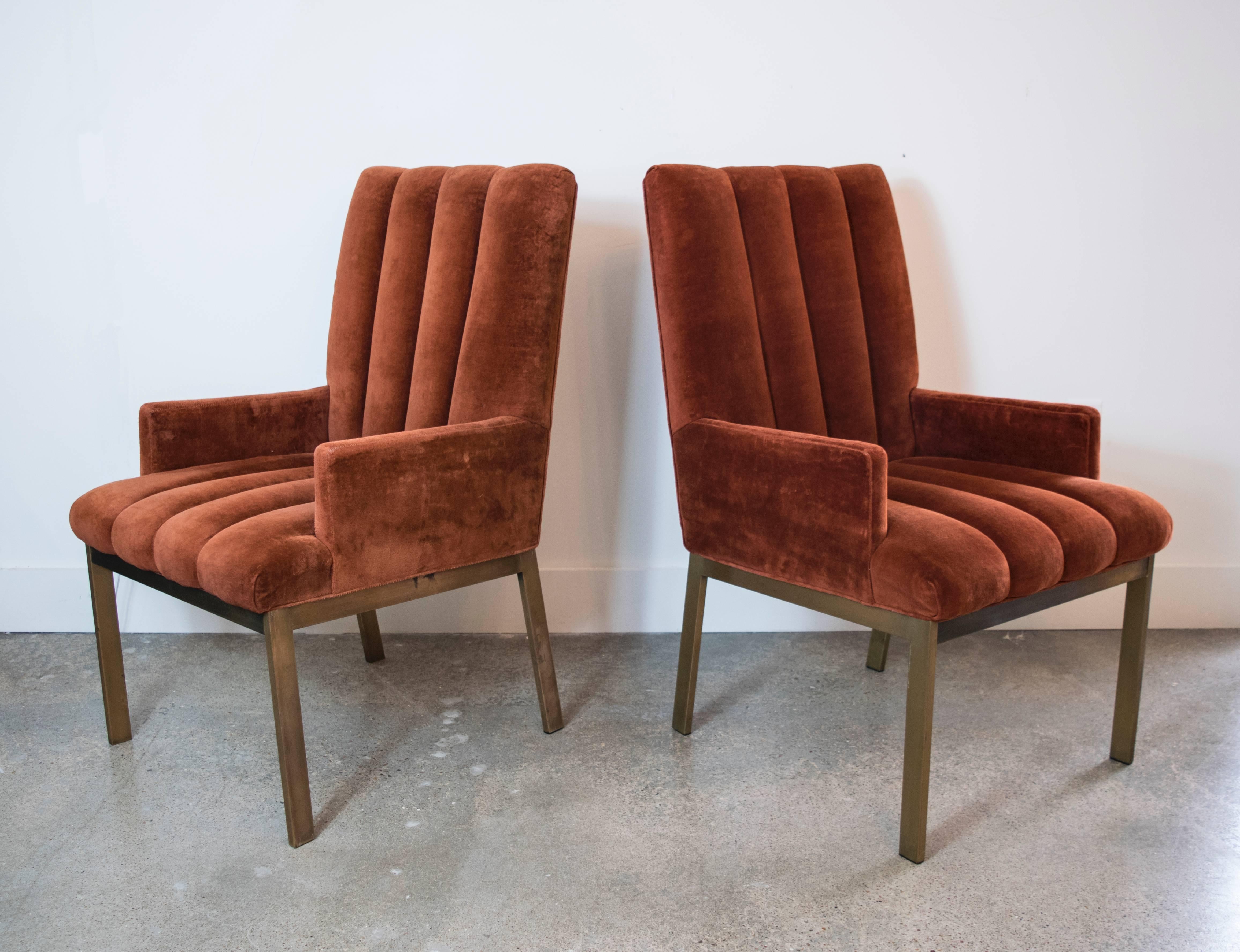 Elegant armchairs with tailored brass/bronze bases and channel tufting in the original rust velvet upholstery. They can be reupholstered in client's fabric for an additional charge.