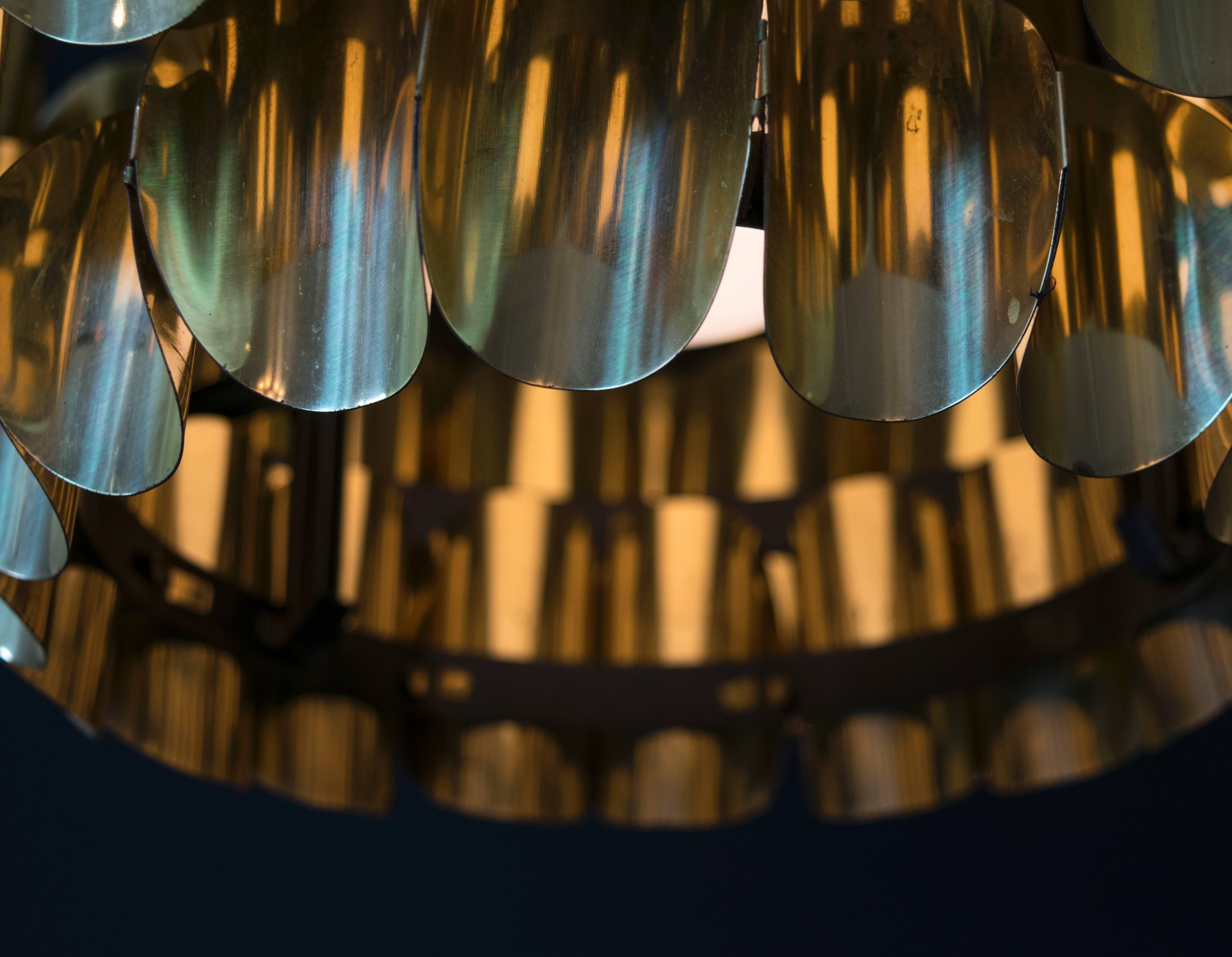 Scandinavian lighting at its finest. This Jakobsson pendant chandelier has five tiers of sculptural brass concave ovals that look like pringle chips fastened together to create a dynamic and bold fixture.