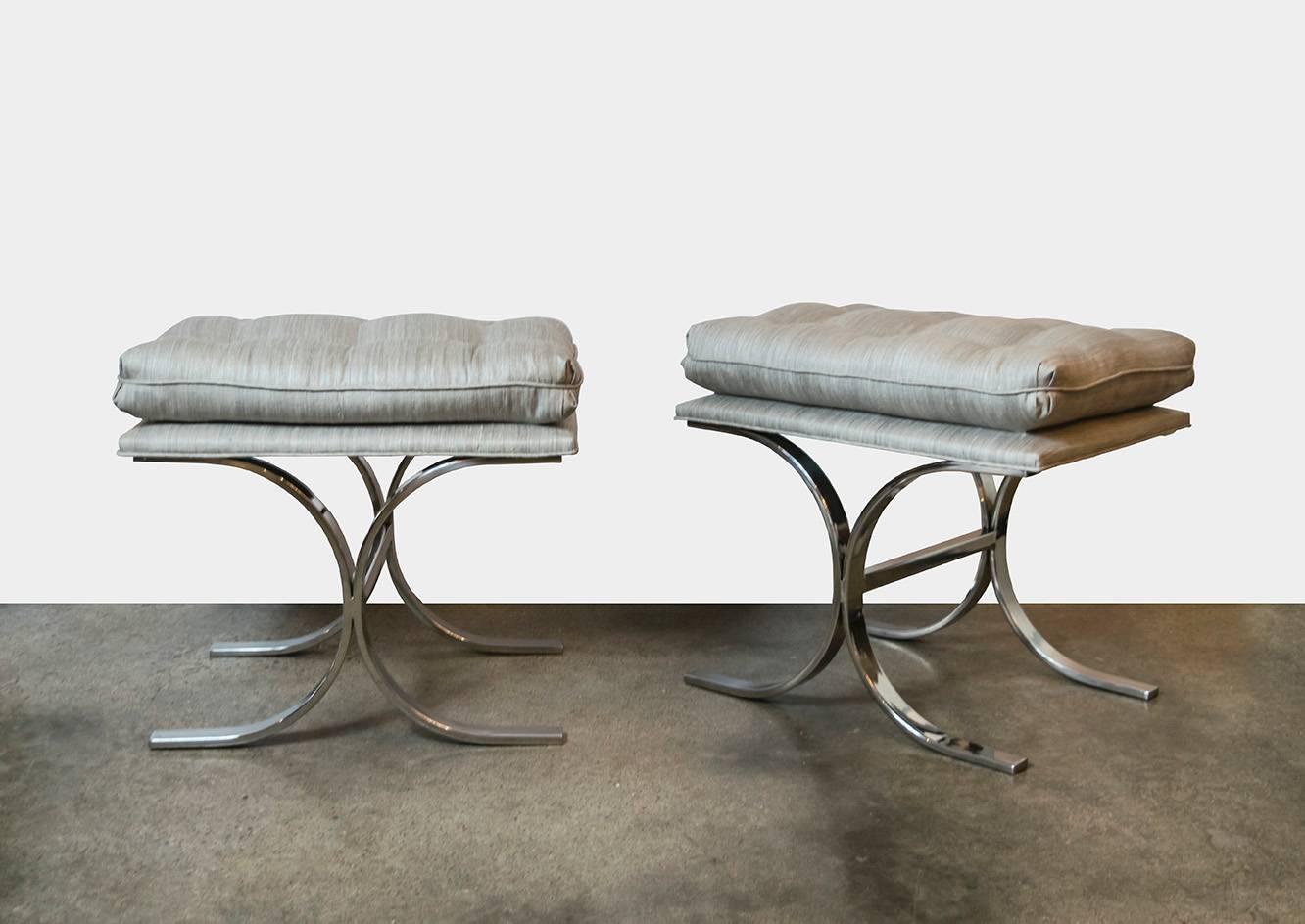 This pair of stools has an absolutely fabulous base design with embedded C-shape. The top seat has a separate but attached tufted pillow. Recently recovered in Holly Hunt raw silk linen in a pale silver.