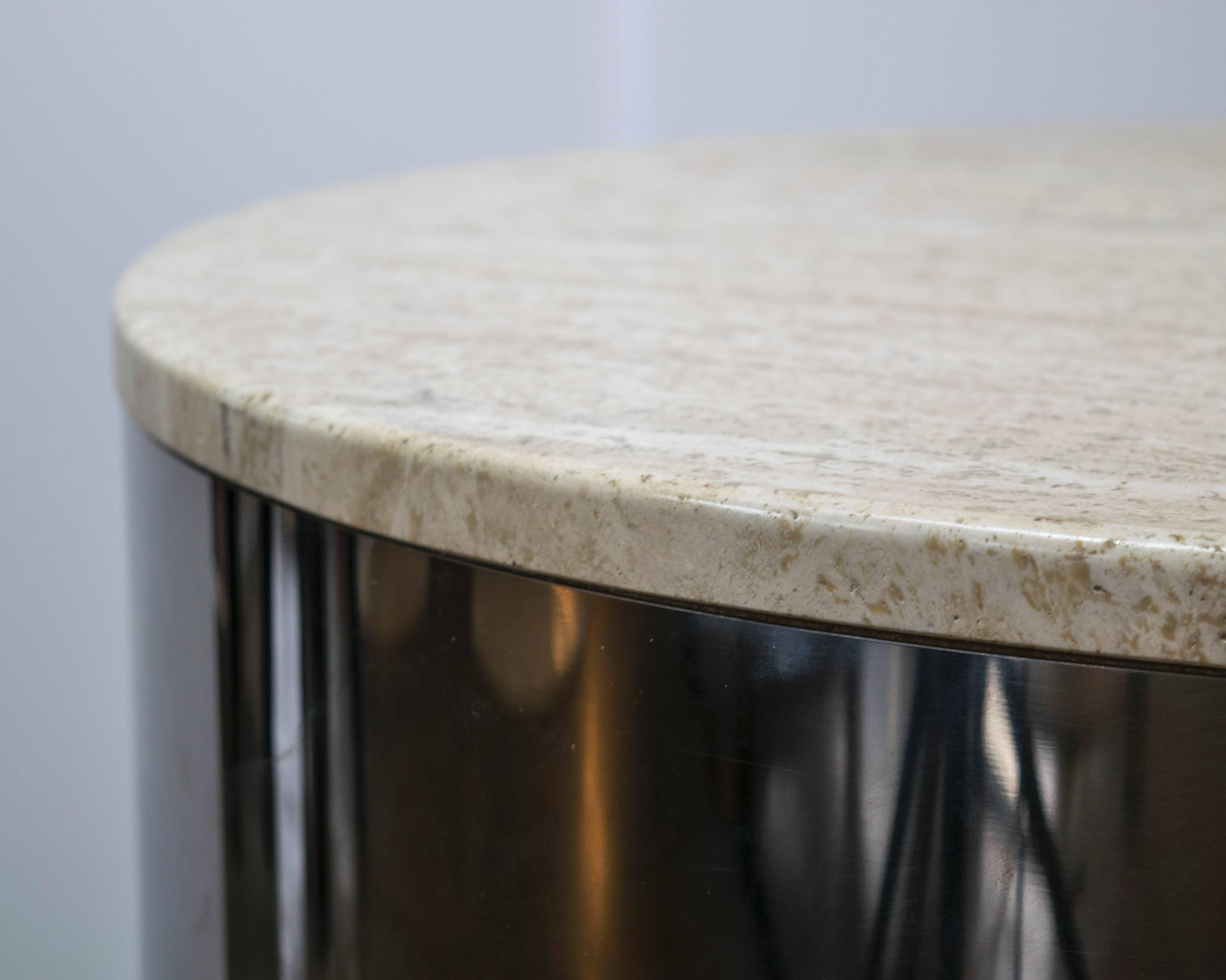Beautiful cylinder drum table made from stainless steel in excellent condition with a polished travertine marble-top. This is a substantial table and could also be used as a pedestal.