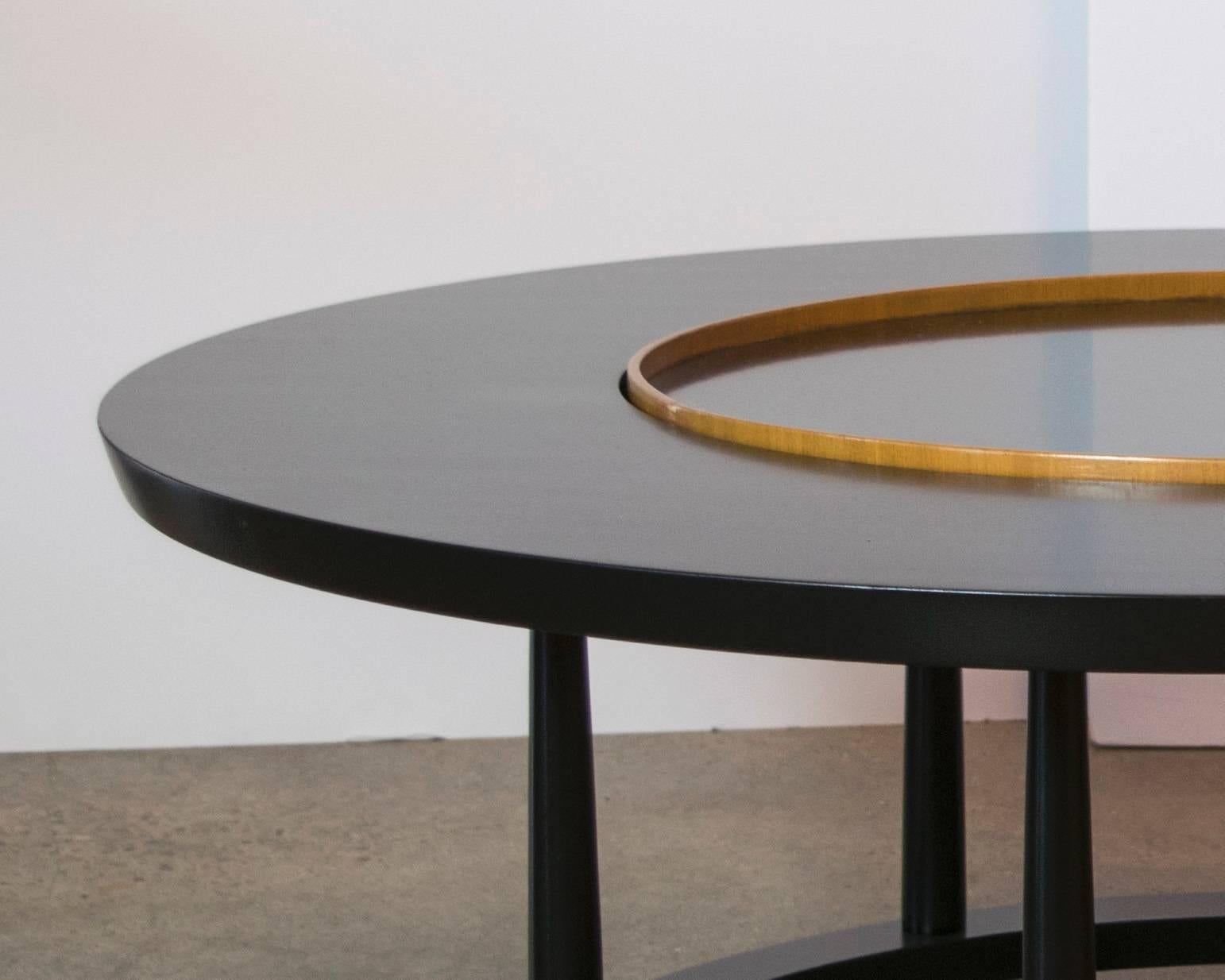 Rare and elegant table by Robsjohn-Gibbings. Ebonized wood base with column detailing and a matching laminate Lazy Susan in the middle.