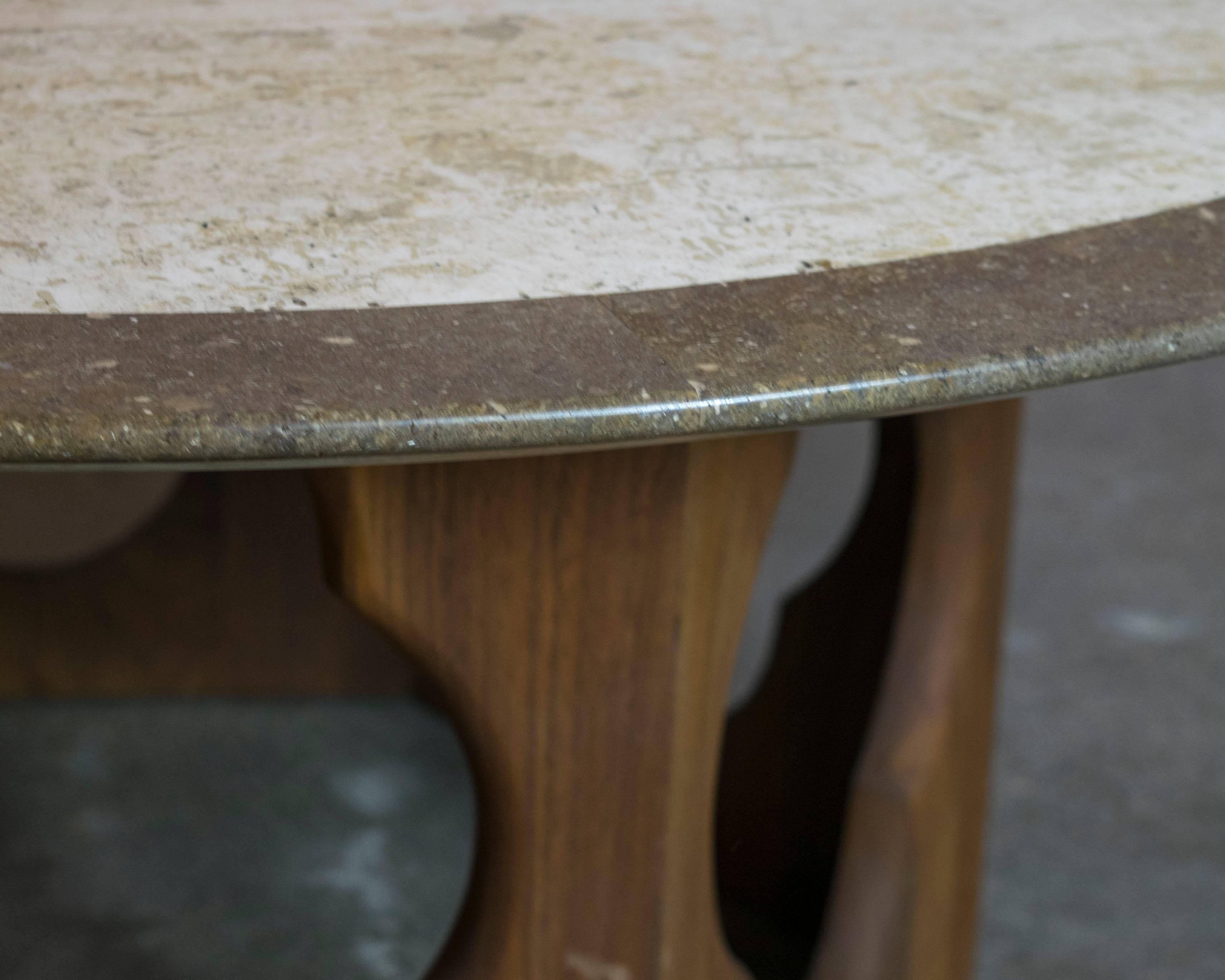 Harvey Probber's creations are characteristically elegant and beautifully executed and this table is no exception. The heavily grained black walnut hexagon base has intricate cut-out details. The top is made of travertine and marble with a circular
