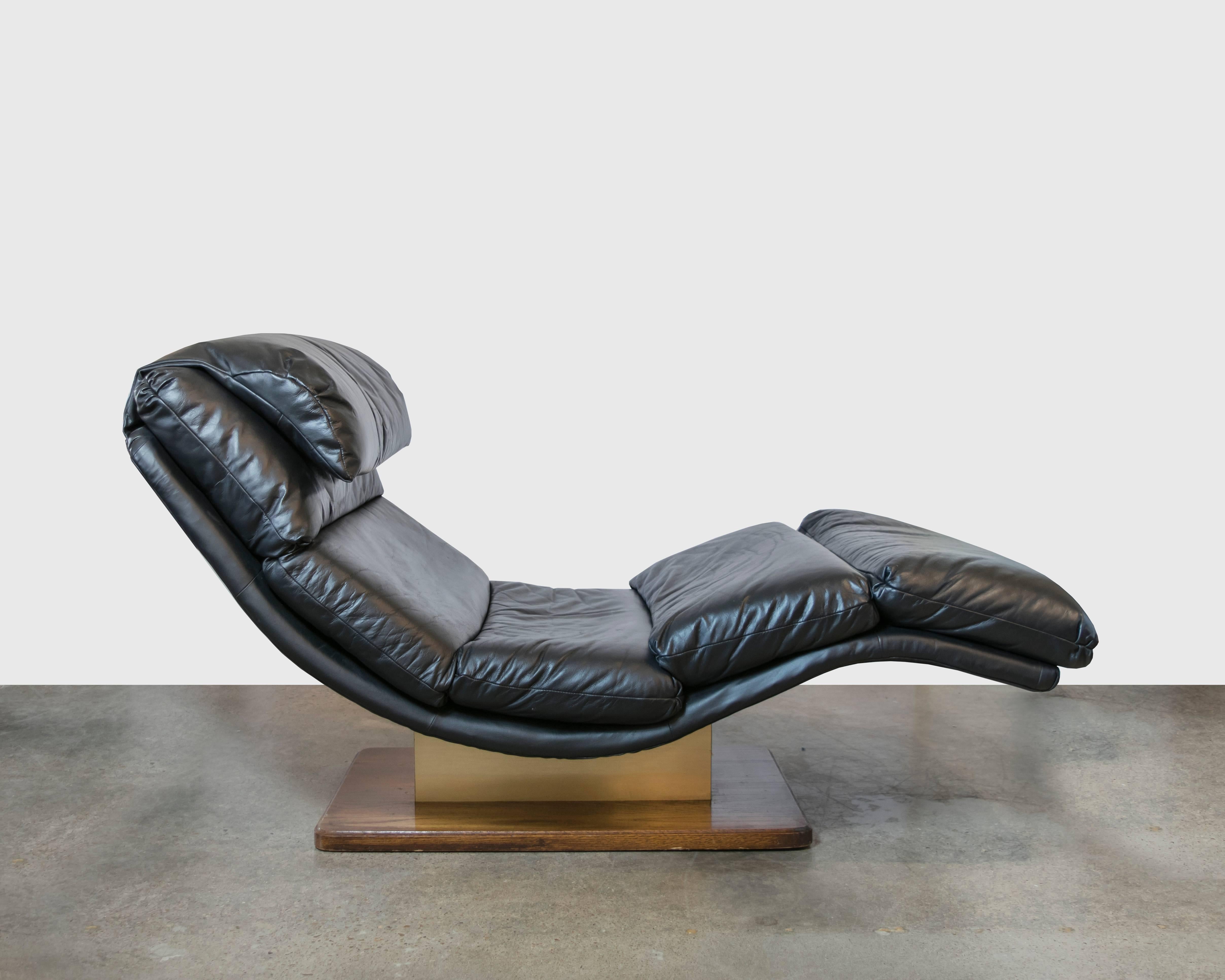 The best looking and most comfortable living room chaise for television watching or reading a good book. This wave shaped chaise sits on a wooden platform with a metallic column holding the chair up. Covered in distressed black leather.