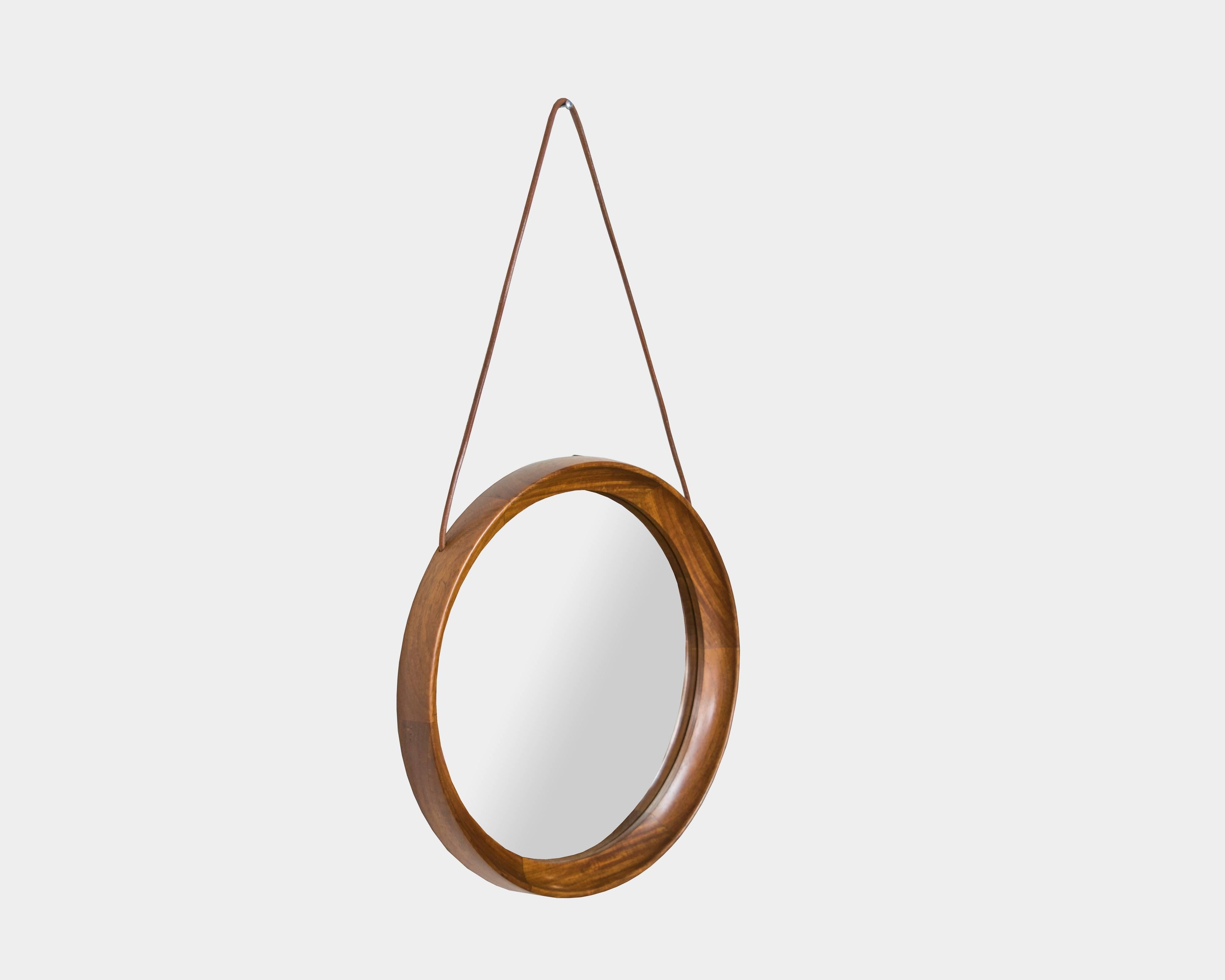 A Mid-Century Modern rosewood round mirror with leather hanging strap.