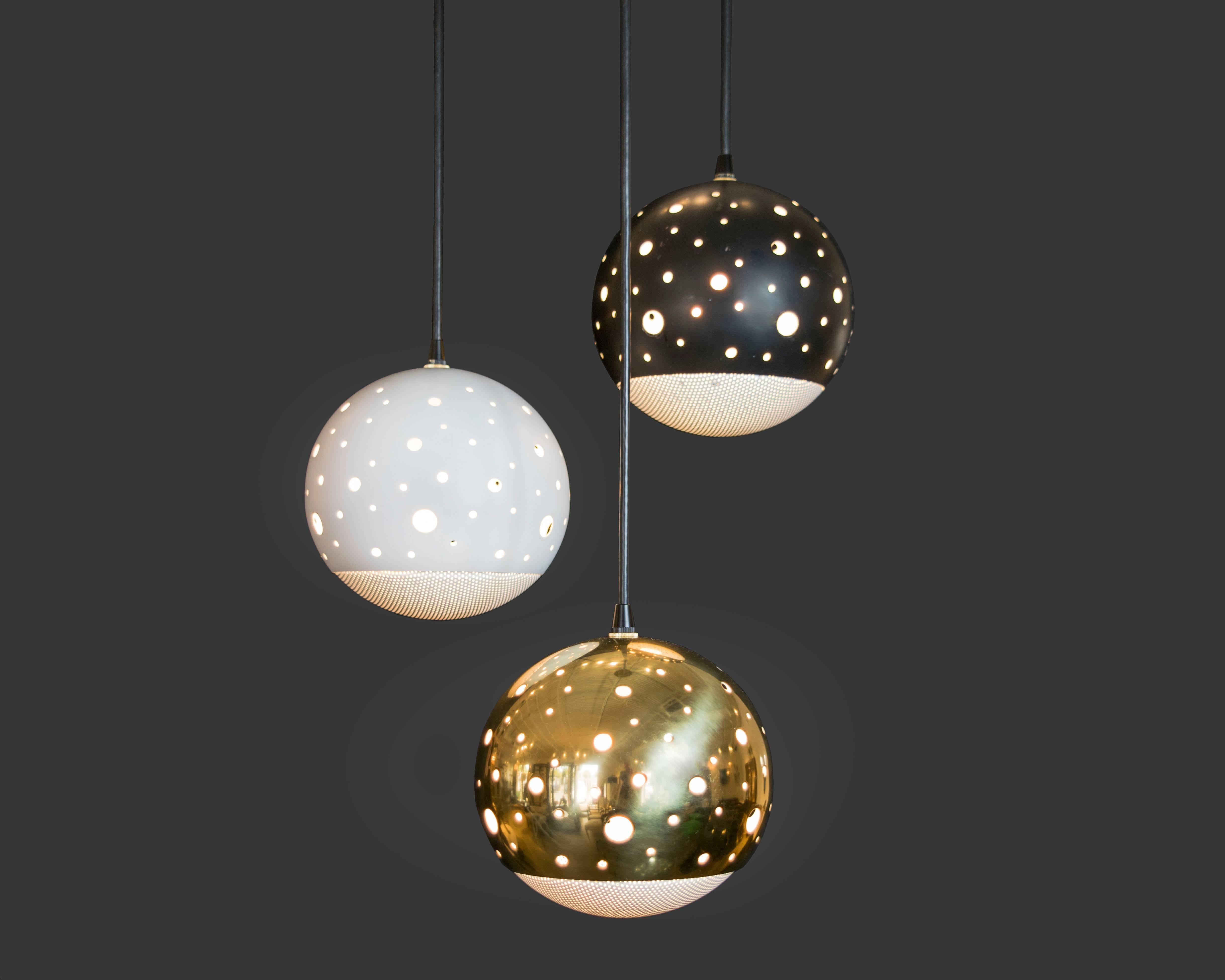 We've never come across another chandelier quite like this space aged three globe chandelier by Lightolier. The globes are perforated with varying sizes of circles and they have a wire mesh base. The globes can be adjusted and the light was recently