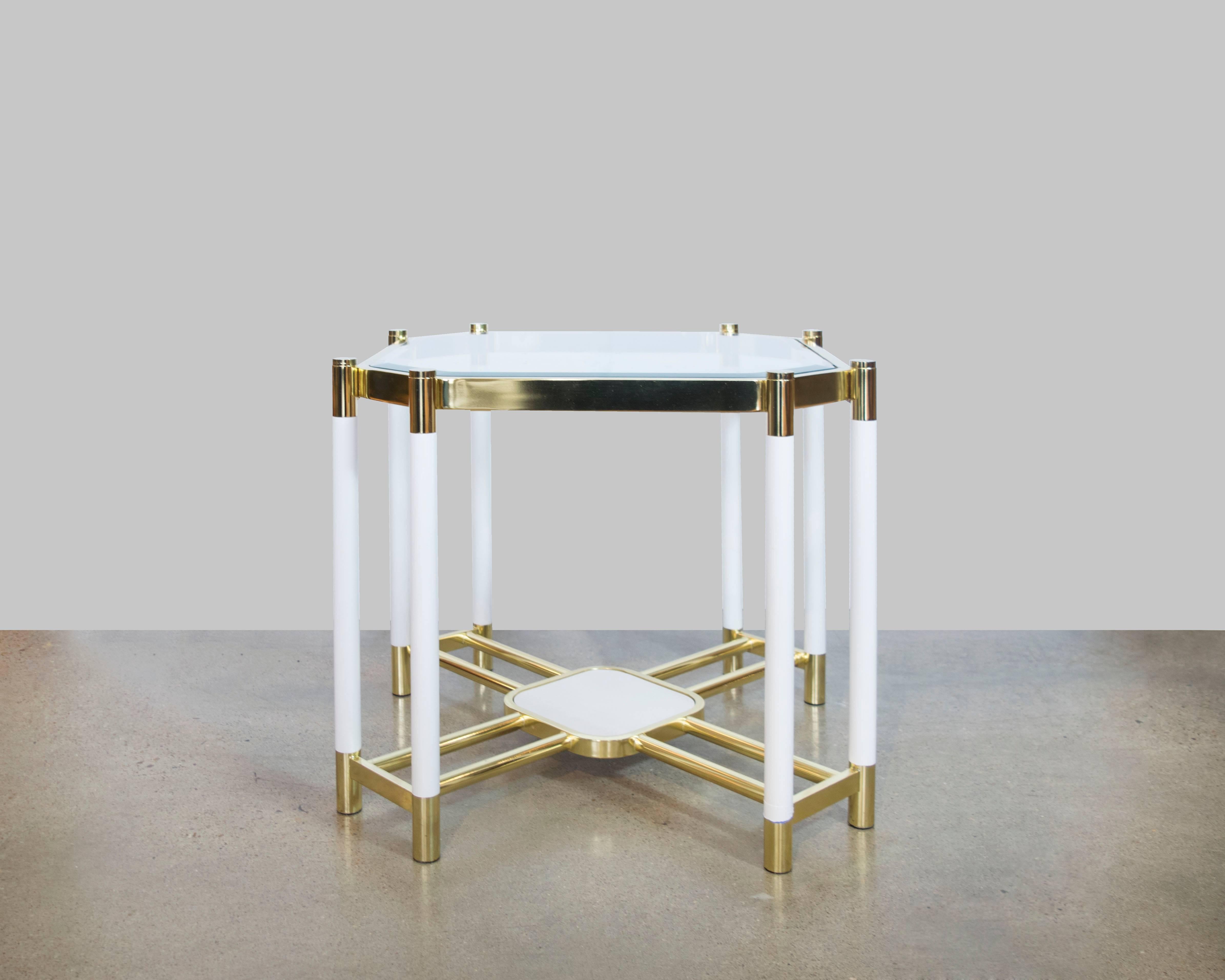 These brass and white lacquer oversized end tables by Mastercraft are exquisite in detail and design. There's a lower small shelf extended with eight brass rods and eight lacquer and brass legs. The glass tops are beveled. These tables are in