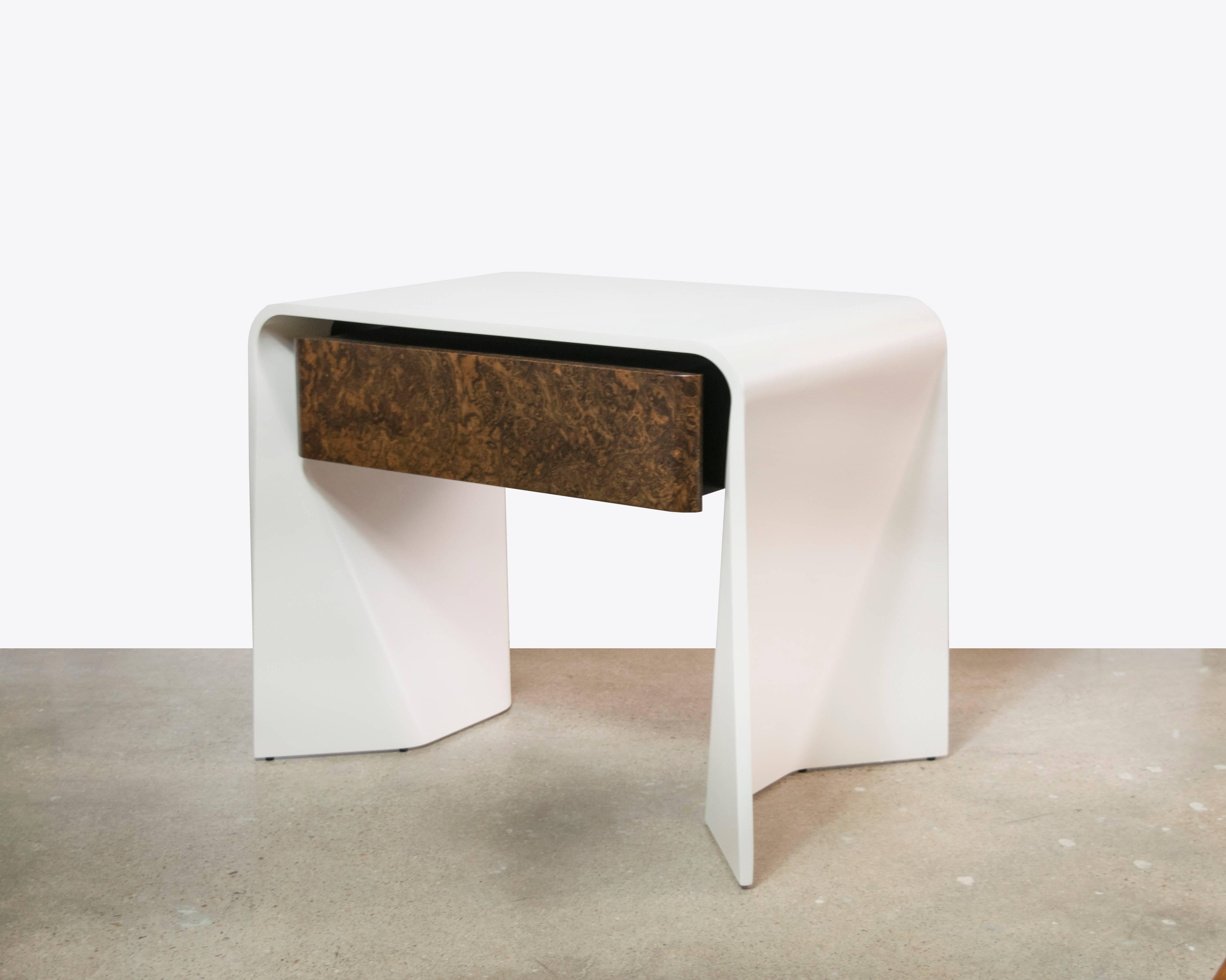A fabulous new Donghia side table or end table with a sculptural lacquer shell and one burl wood laminate drawer. This is a very beautiful piece.