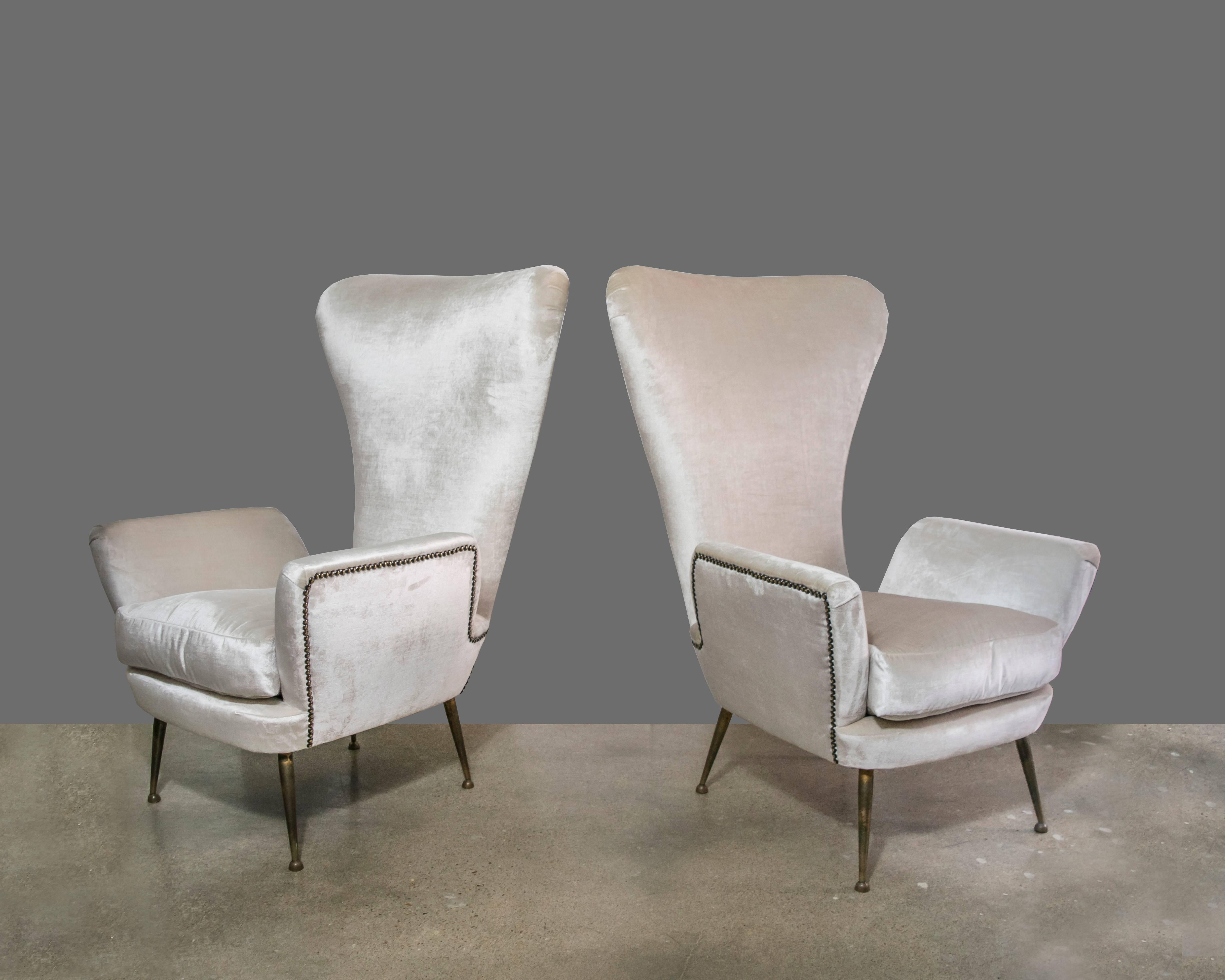 Luxurious pair of Paolo Buffa Mid-Century Italian chairs with unusually high seat backs providing a nice head rest for reading or relaxing. These chairs have recently been recovered in a Donghia velvet and are outfitted with brass studs. These are