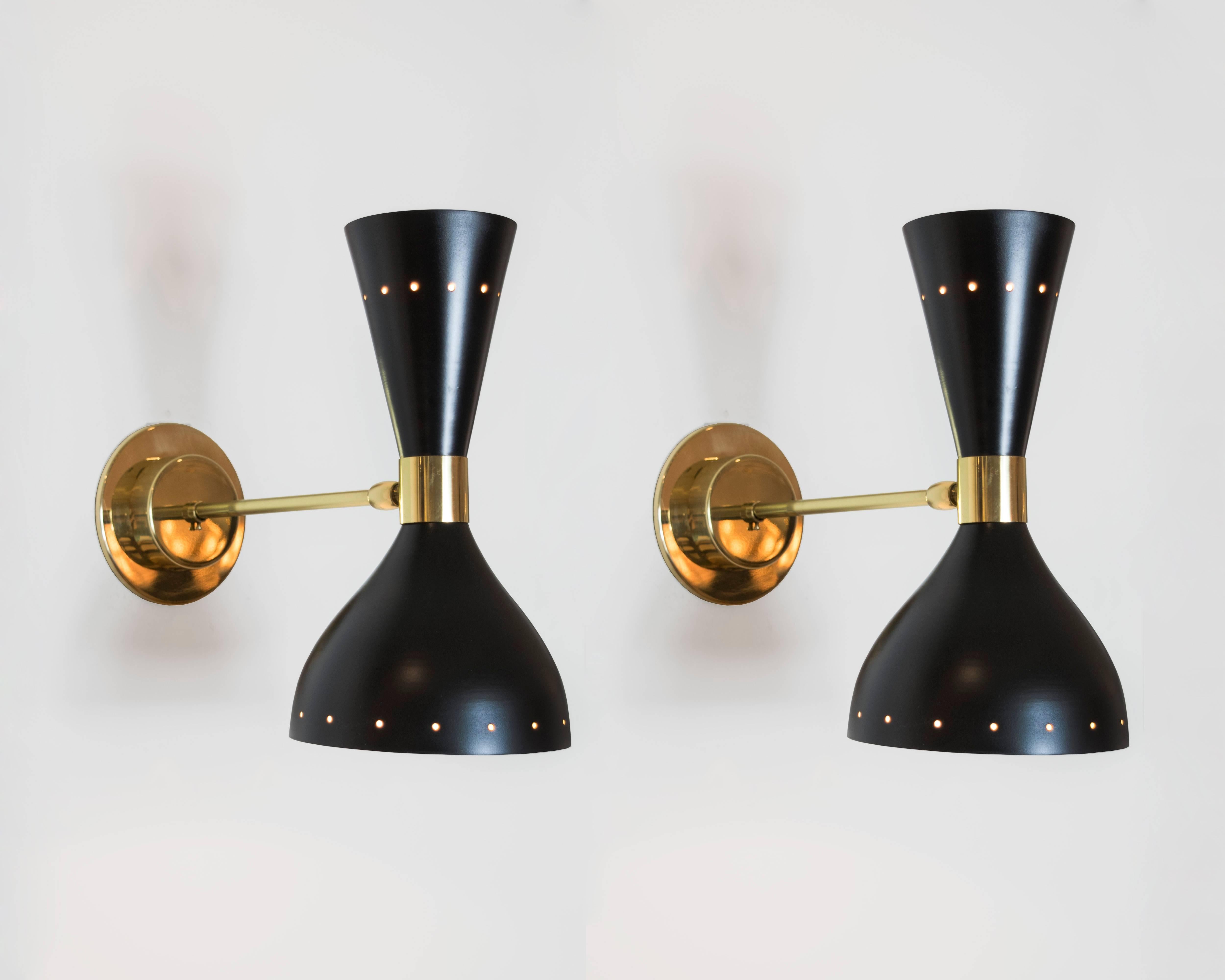 A pair of Stilnovo black lacquer and brass sconces with both up and down lighting in a conical shape. The outer rim extends 11.5 inches from the wall and the upper cone has a ring of perforated circles to add more drama to the pair. (A white pair is