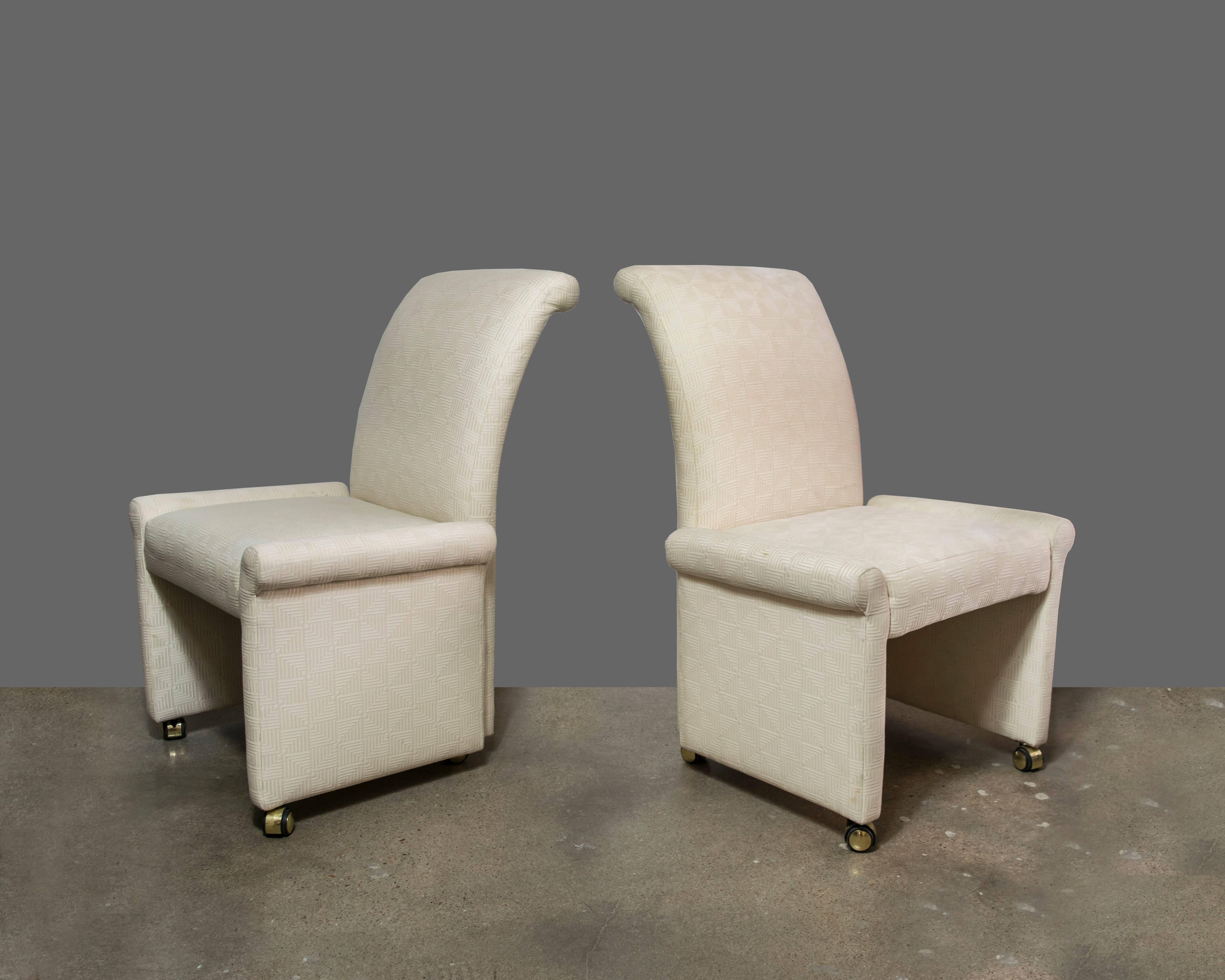 A set of six high back upholstered dining chairs by Milo Baughman for Thayer Coggin ready for upholstery. Two armchairs and four side chairs on brass rolling wheels. We can assist with upholstering with the fabric of your choice for an extra fee.