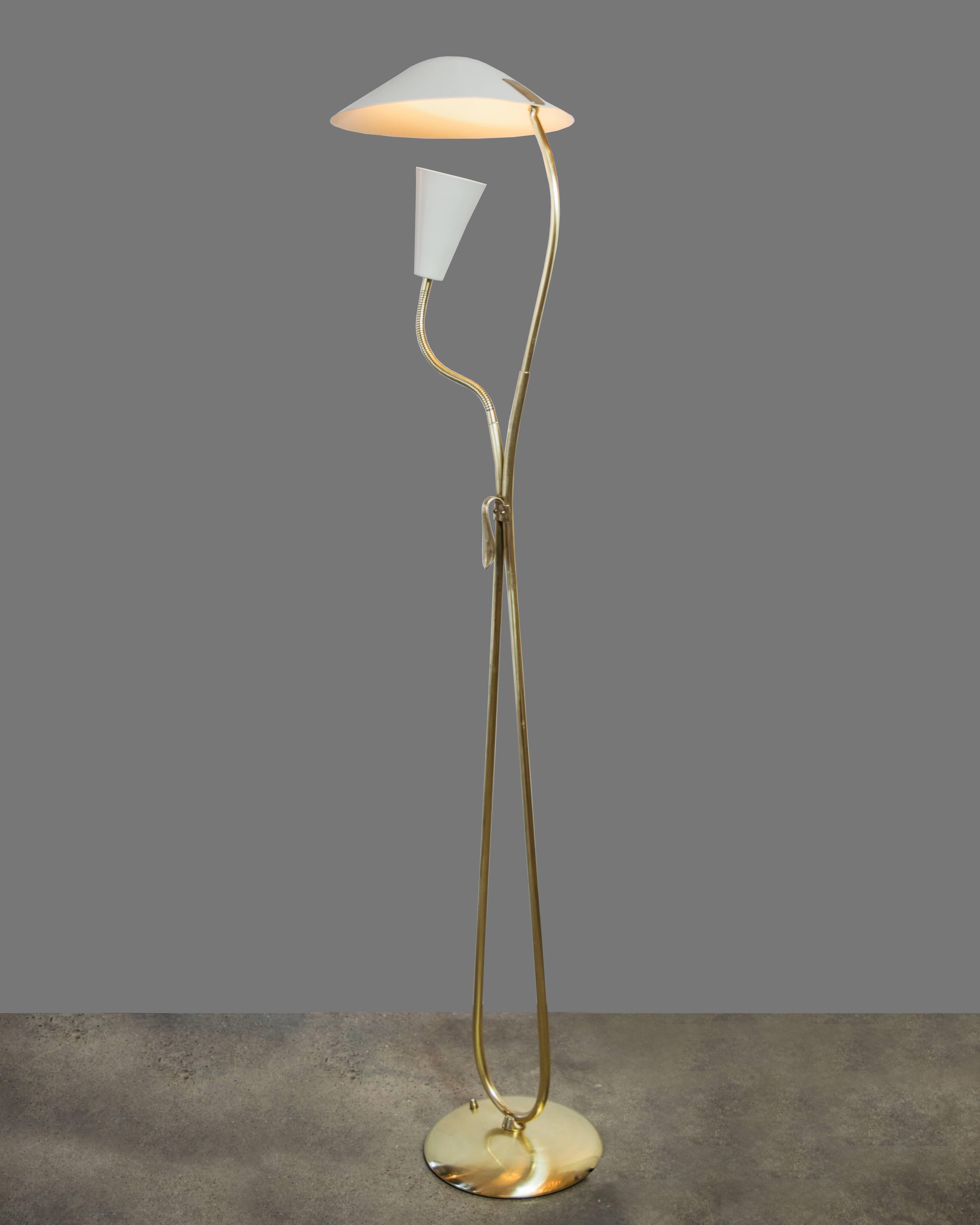 Graceful, sculptural brass floor lamp with a single light cone attached by an adjustable arm directed towards the UFO shaped shade. There is an attached handle in the middle of the lamp for easy adjustment. It comes with a floor switch and is in