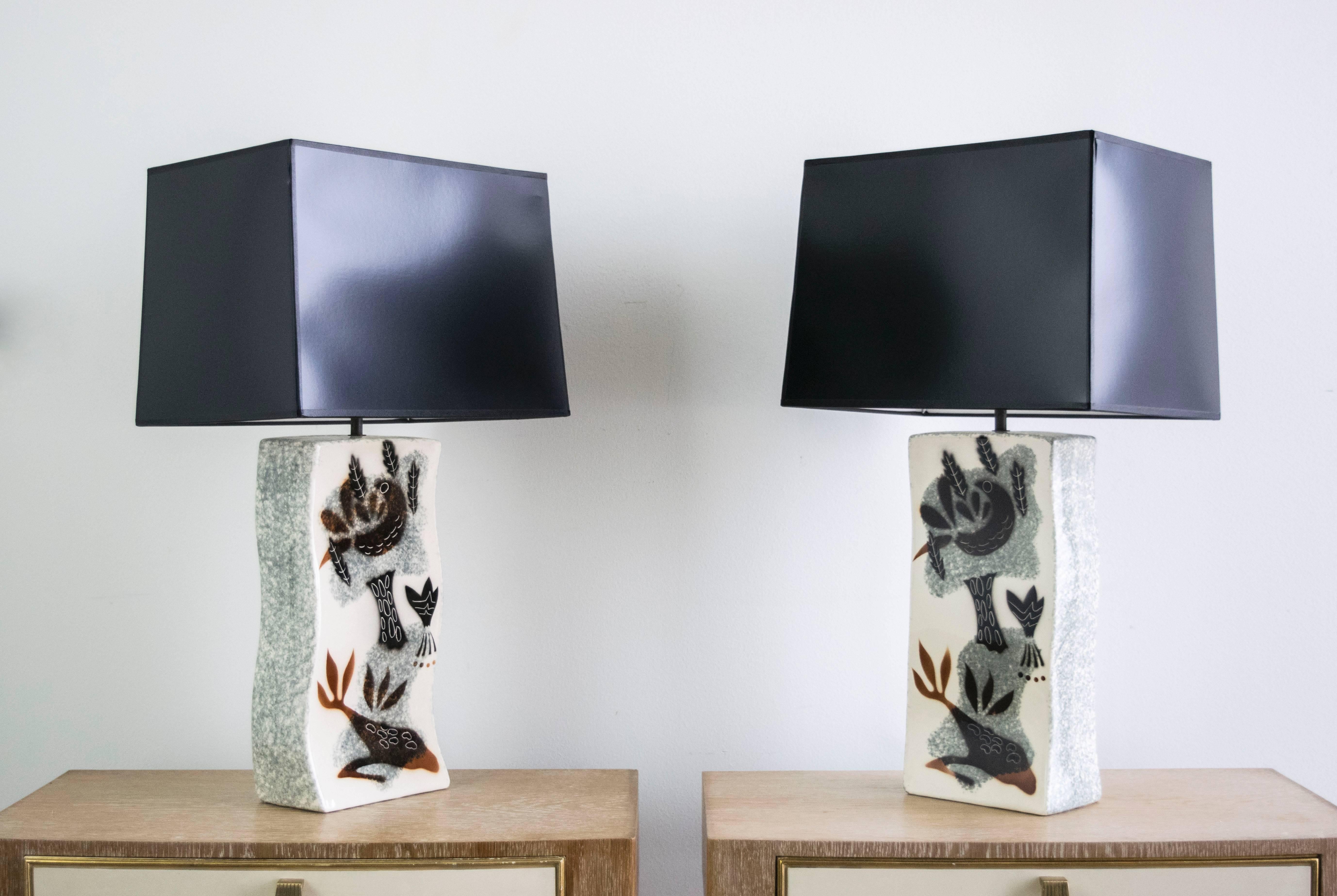 These wonderfully unique lamps have a slight sculptural wave with a speckled grey glaze on the side and an unusual Matisse-like painting on the front.