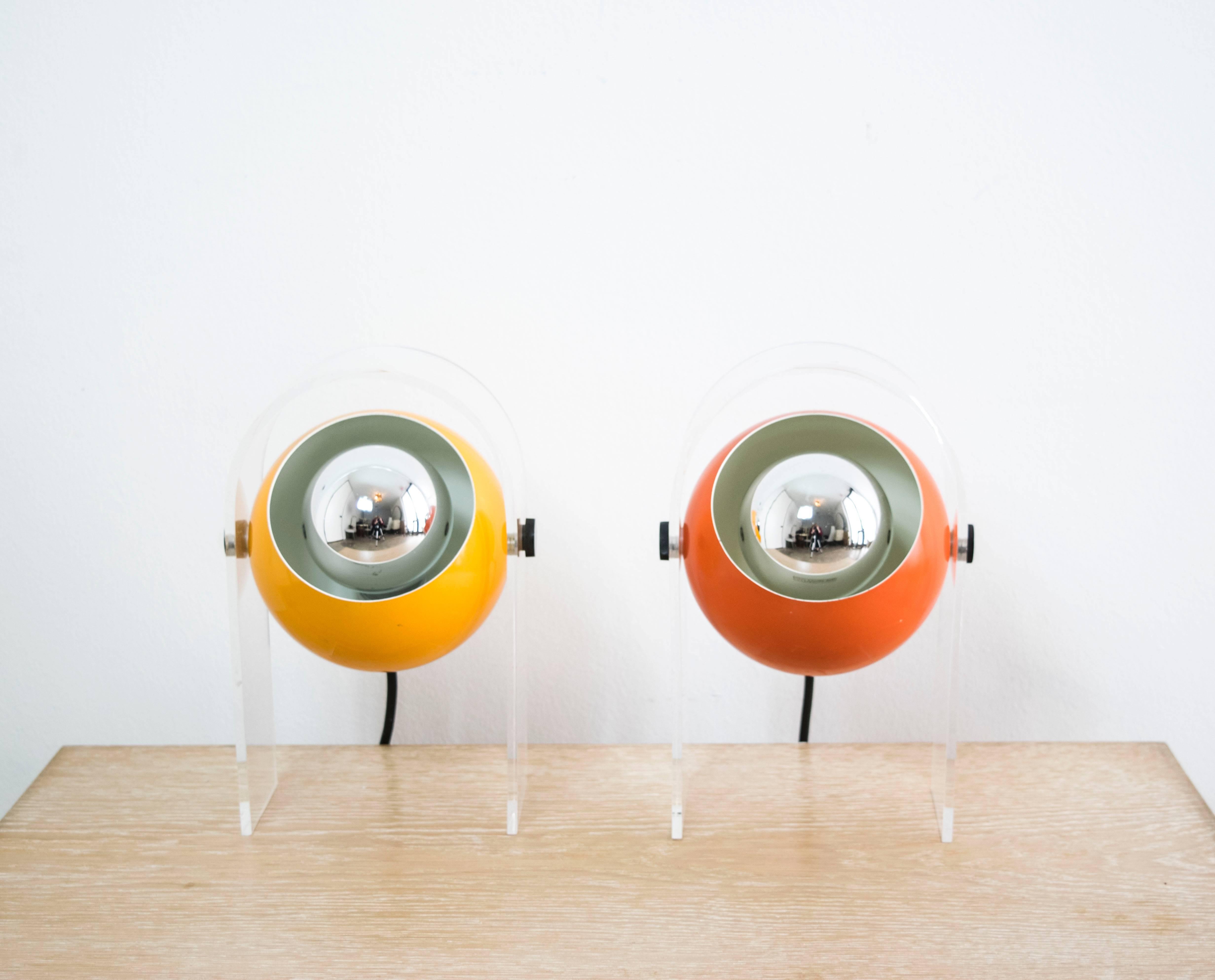 A pair of contrasting orange lucite eye lamps in Op Art style circa 1960s.