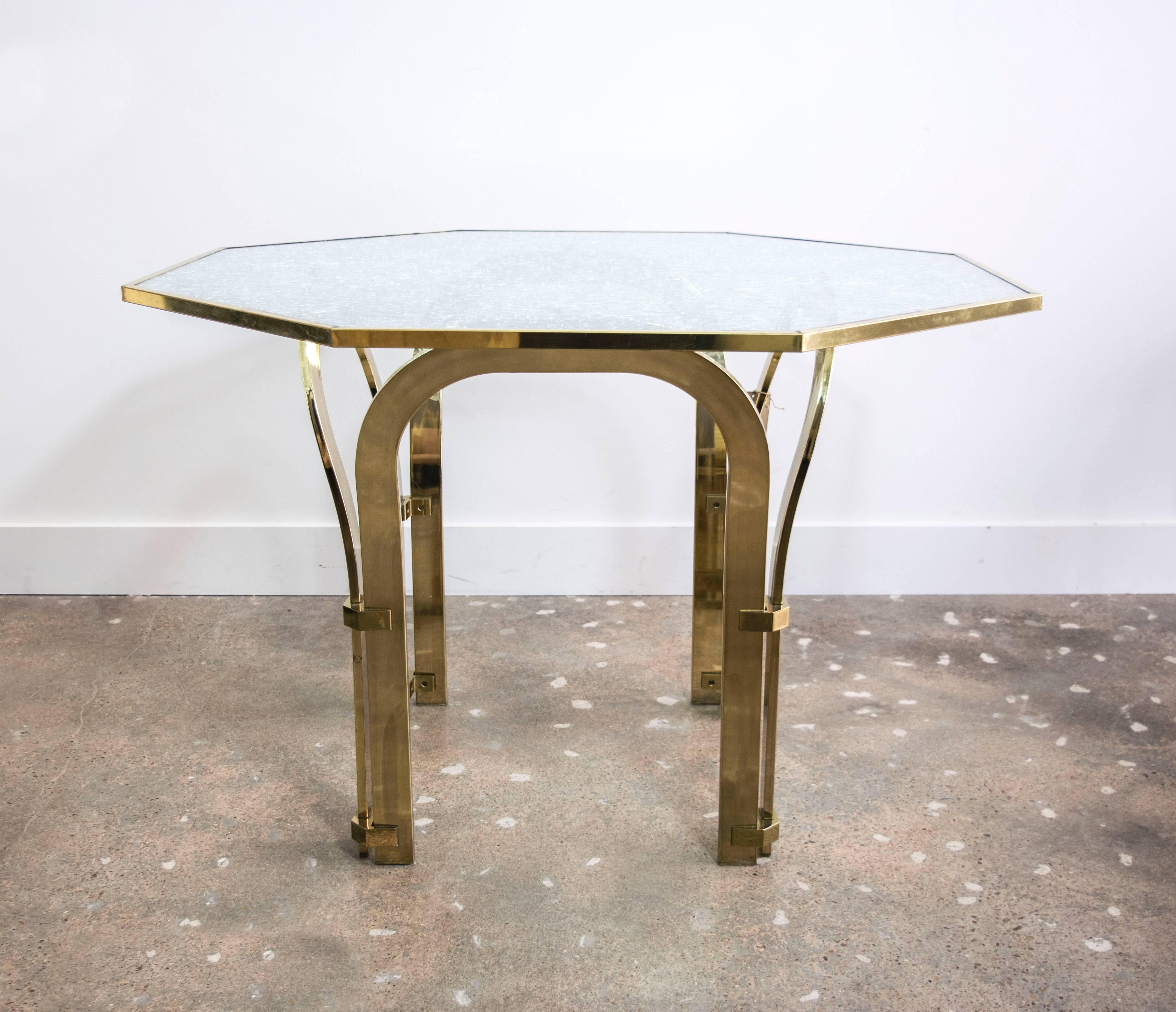 This highly stylized arched brass table is extremely well made and designed.  The original owner had a custom crackle glass top made to look like shattered glass. It is one inch thick and is removable for easy and secure shipping.