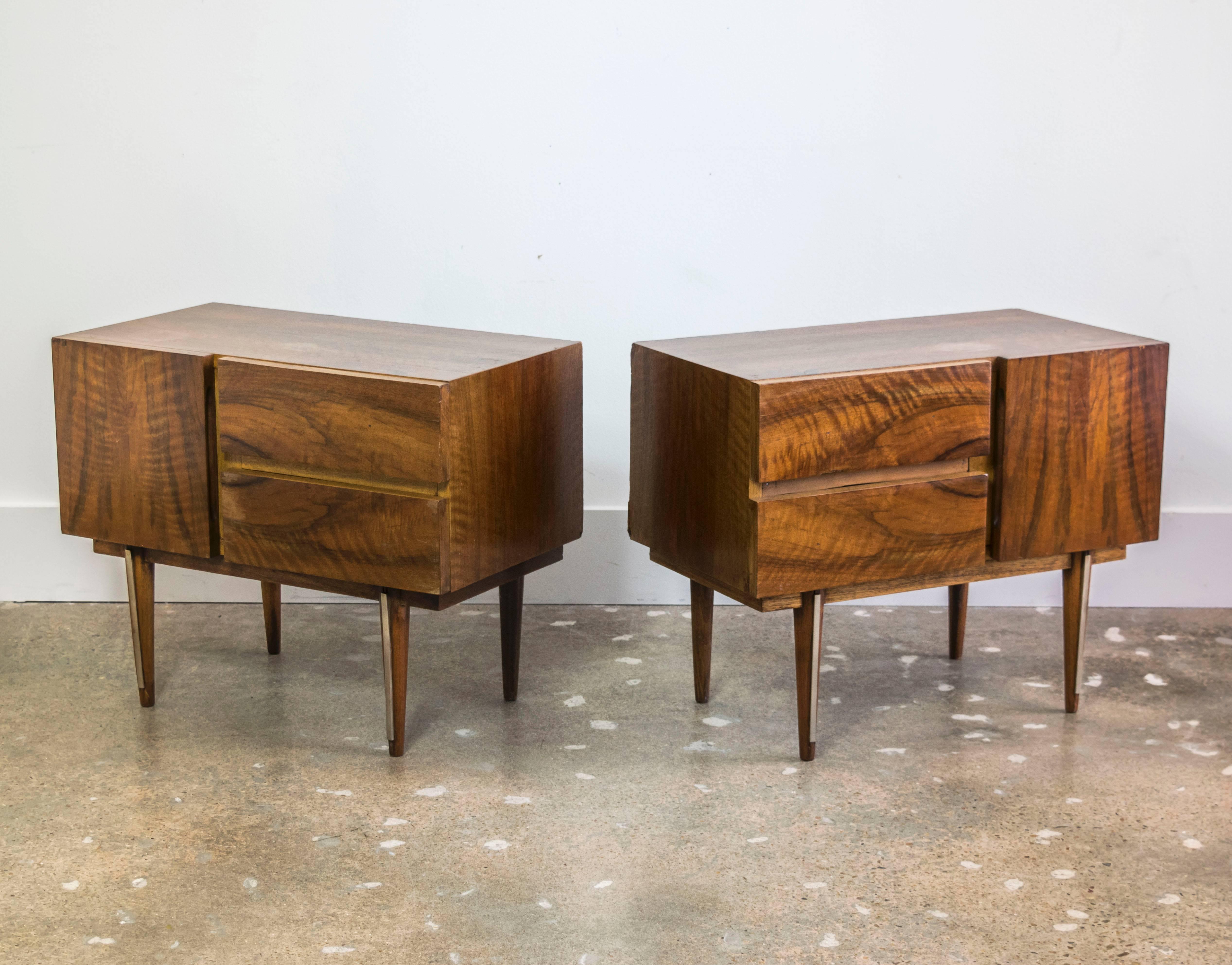 Rosewood bedside tables with brass detailing on the legs, each has two drawers and a separate cubicle space.