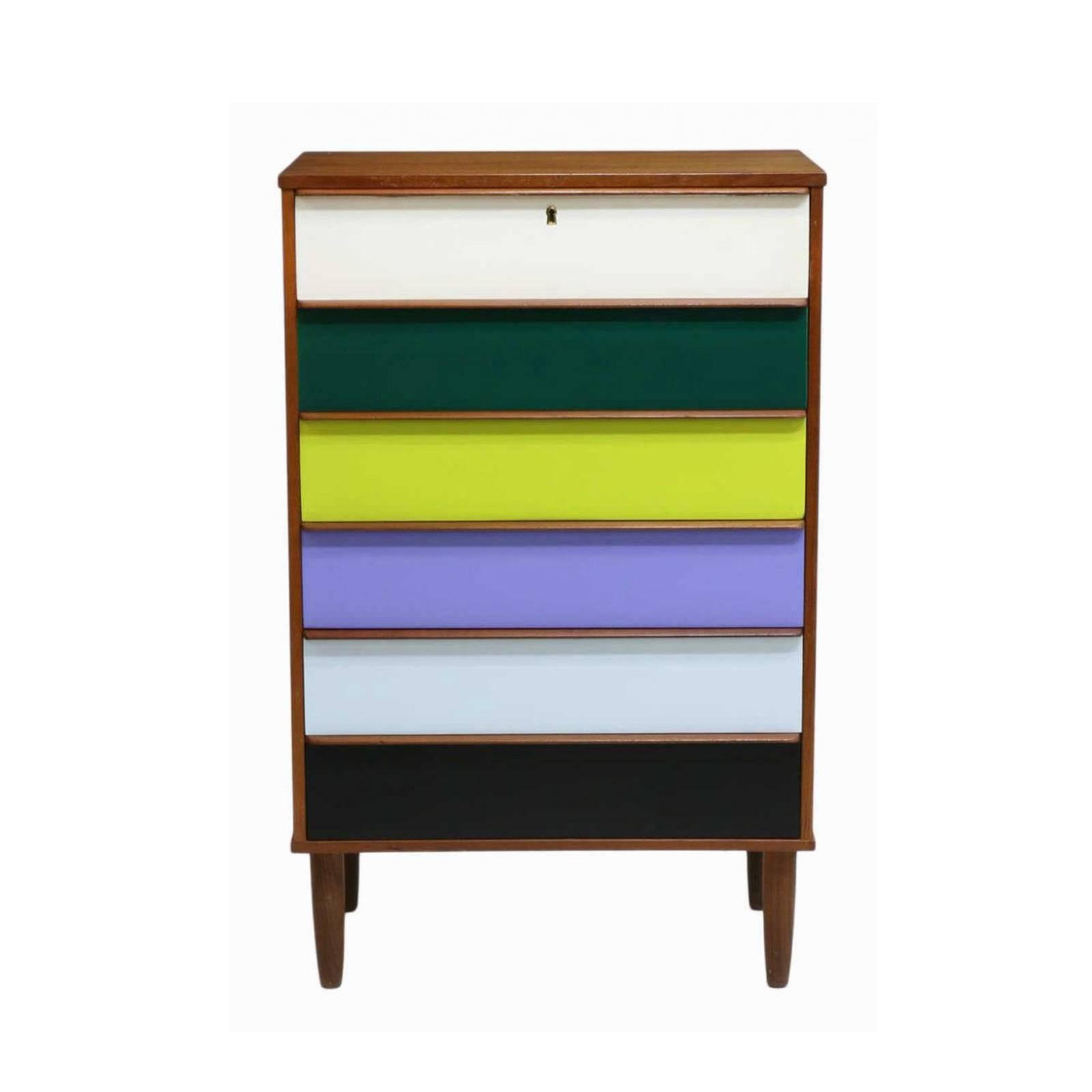 1950s Danish Mid-Century Modern teakwood chest of drawers on tapered legs. Each of the six faces is painted in beautiful different vibrant colors.