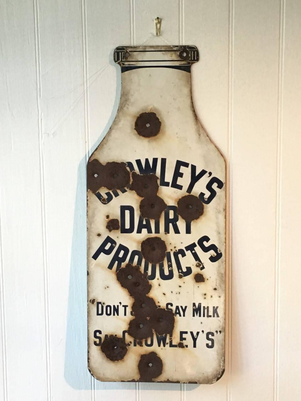 Americana blends seamlessly into folk art with this double-sided enamel dairy trade side, later utilized for target shooting, mid-20th century.

Advertisement reads:
Crowley's Dairy Products.
"Don't just say milk, say crowley's."
 