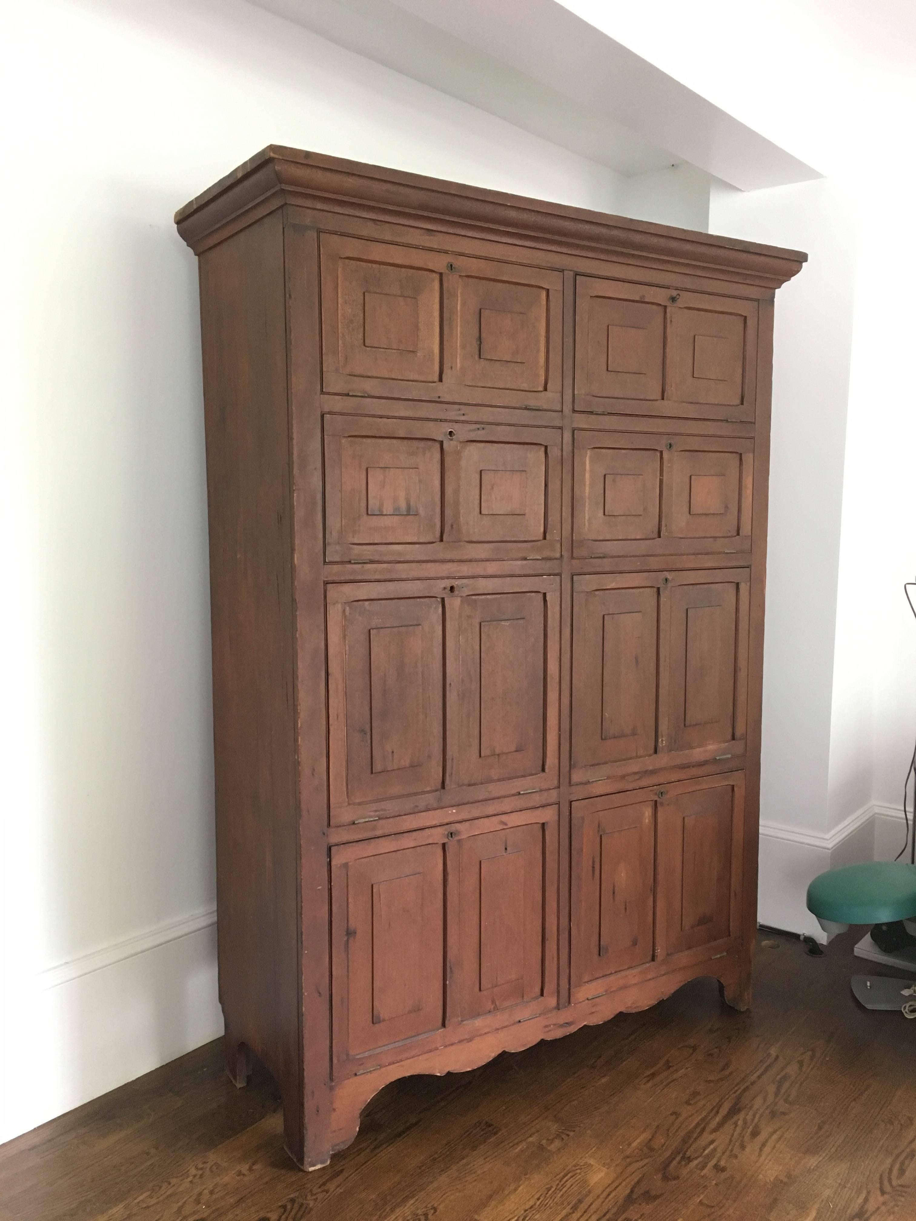 Rare and important early 19th century Shaker cabinet with drop down lockable doors; made of poplar, original finish, one single trefoil iron key. Upstate New York or New England.