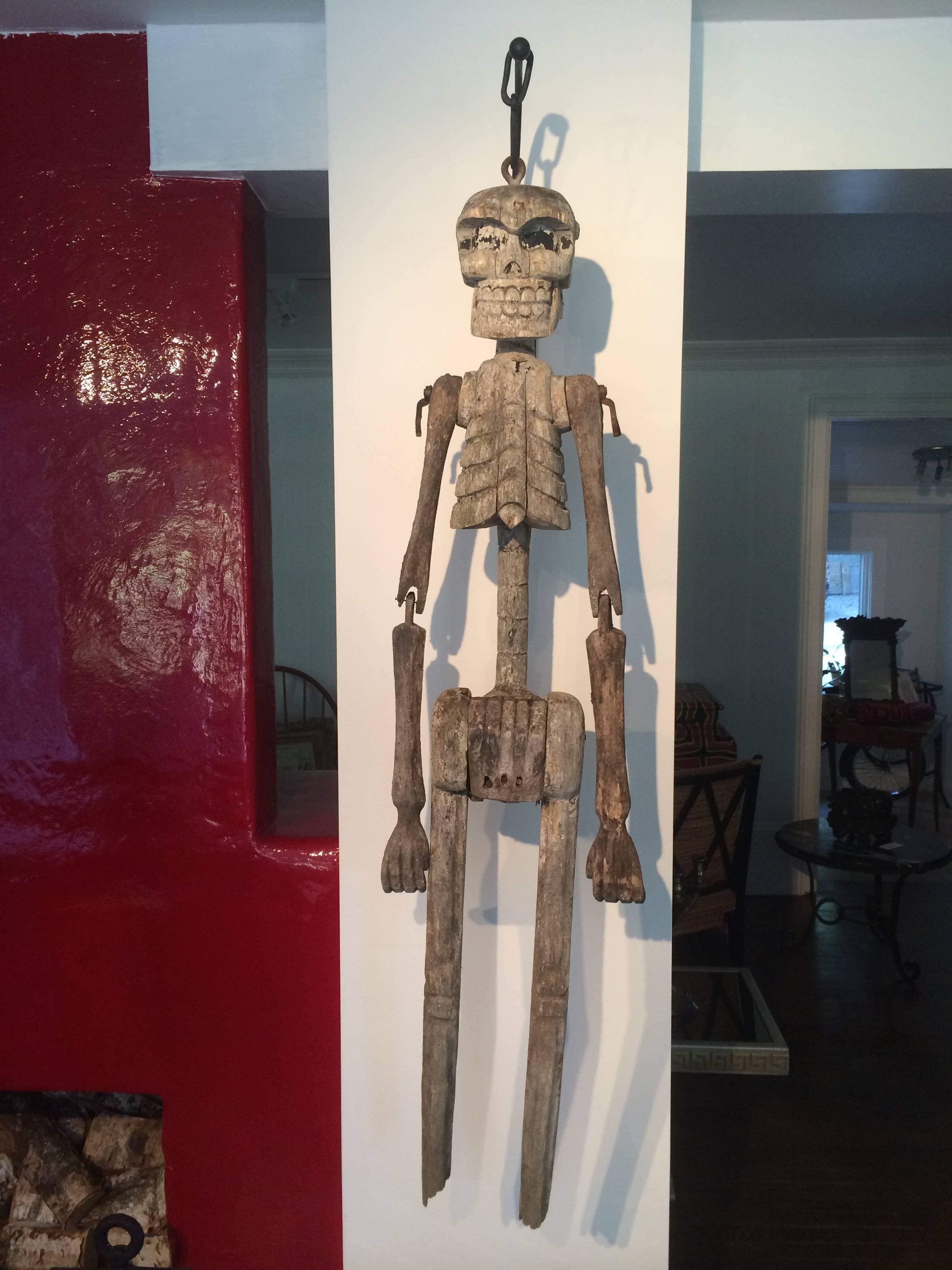 An early 20th century, Mexican "Day of the Dead" carved cactus articulating skeleton. Custom (new) iron wall hanging mount included.