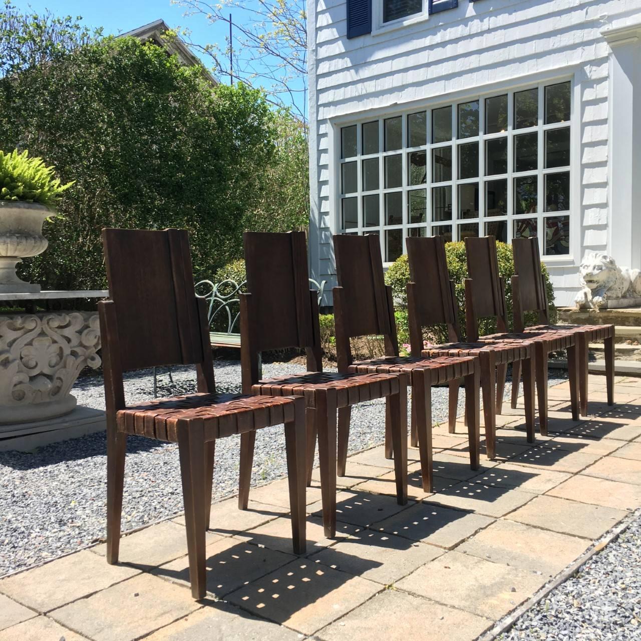 Modernist dining chairs (set of six available) each having wood panel back over woven leather seat all supported on tapered legs, circa 1940.

