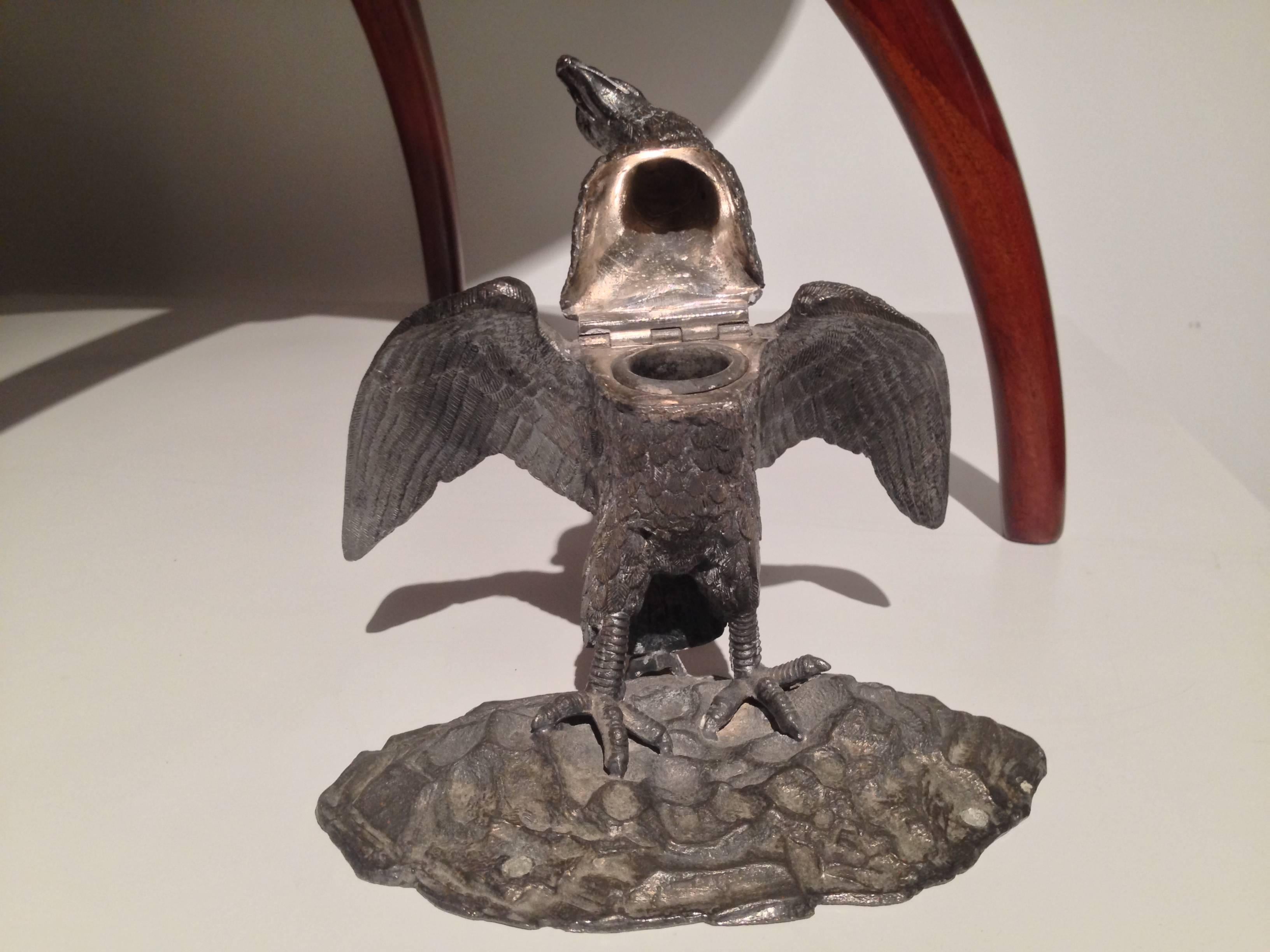 A late 19th century English silver plated eagle form inkwell with hinged head, which raises to reveal the original metal well insert.