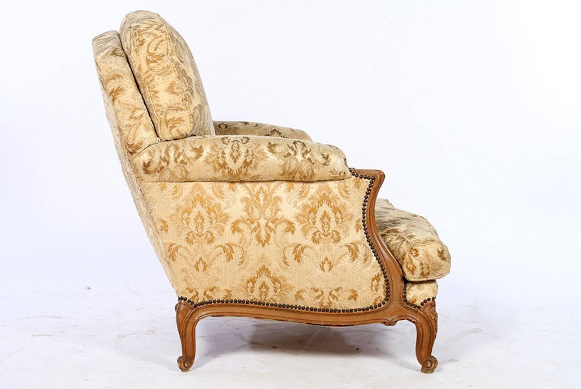 A pair of French Louis XV style carved walnut upholstered bergeres.

Dimensions: Height 38", width 28", depth 34".