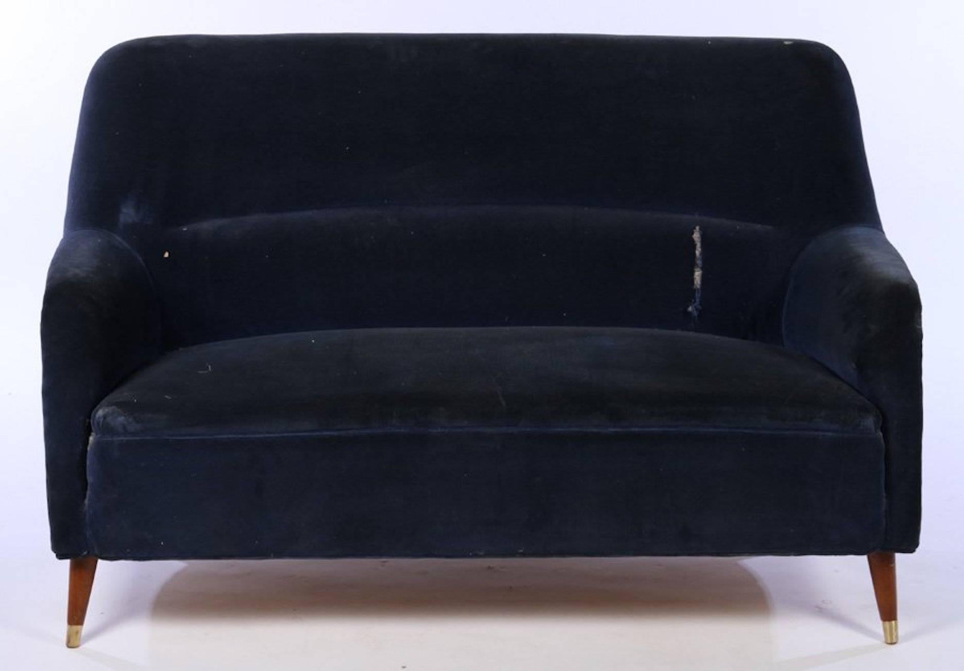 A Mid-Century Modern velvet upholstered love seat having arched back and down swept arms raised on tapered and turned legs, circa 1960. 
.
