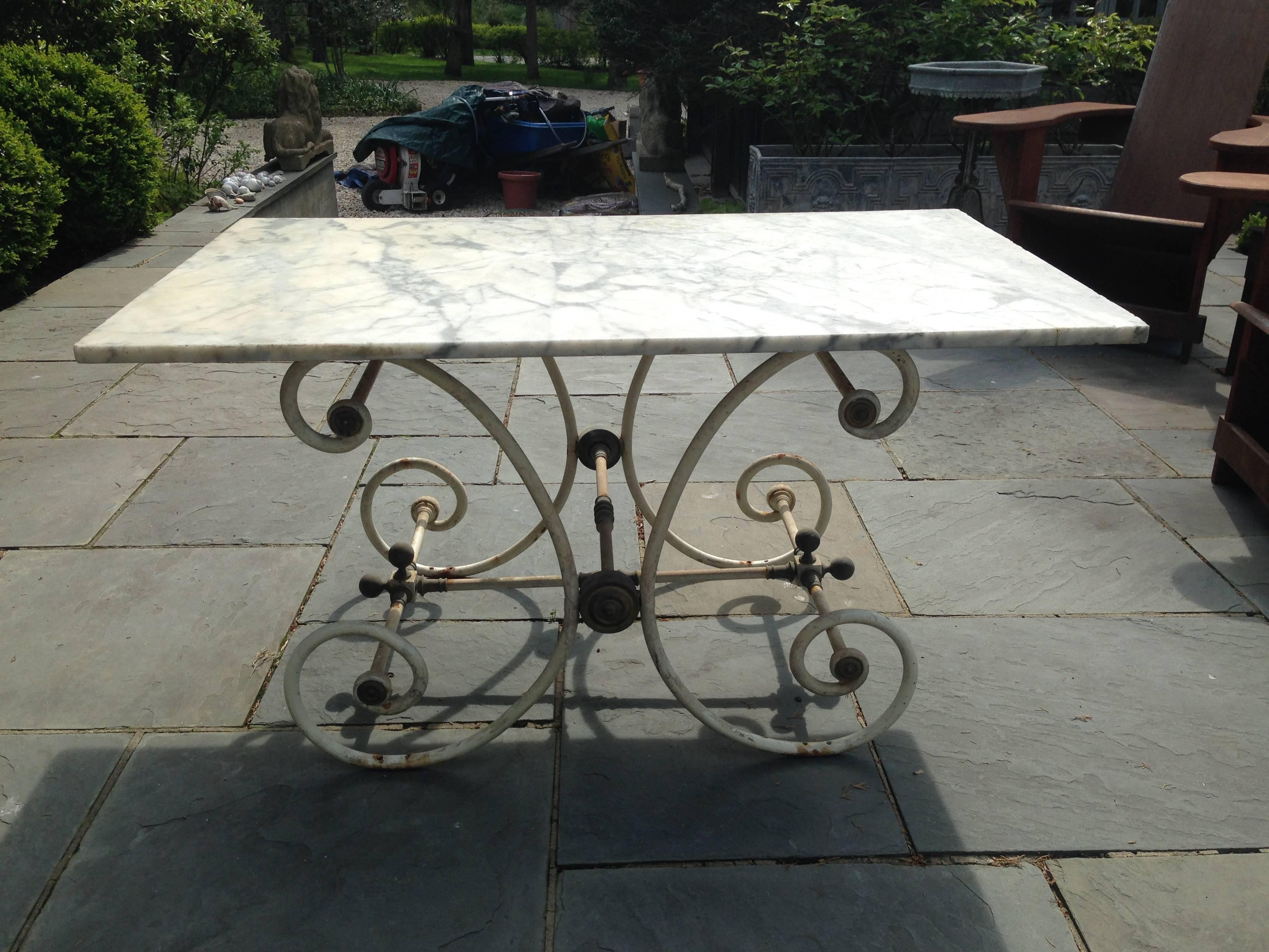 A late 19th century French pastry table with an old white marble top resting on the white painted base with brass decorative elements.