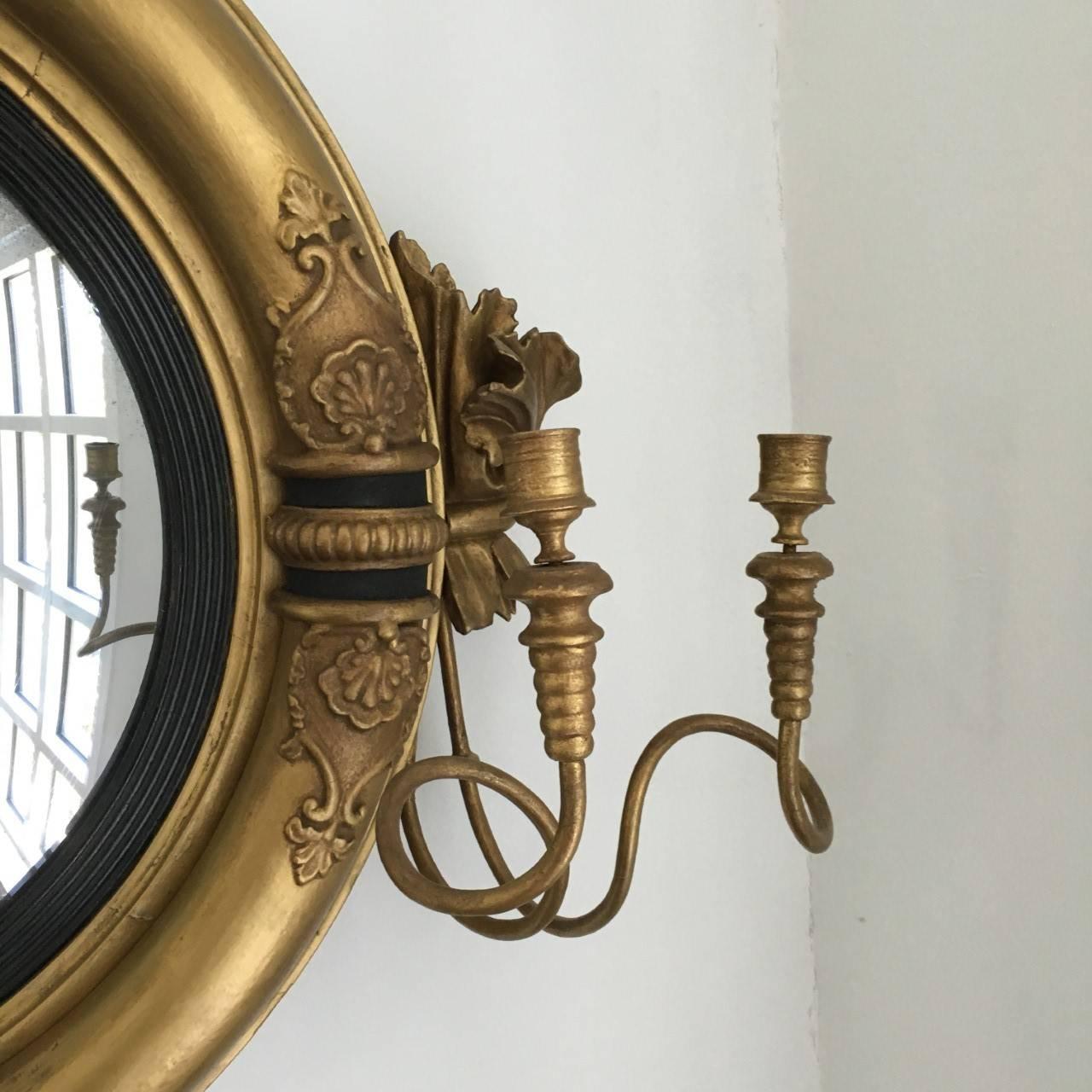 English Regency period convex girandole mirror, circa 1810-1820.
