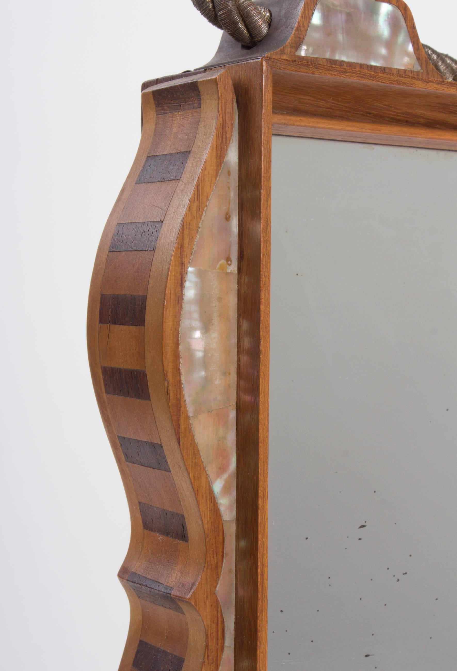 A beautiful example of Viennese design as promoted by the Secessionist movement during the early 20th century.

The curved oak mirror corpus as a simple but elegant stripe inlay of cherry and nut at the sides, the front decor consists mainly of