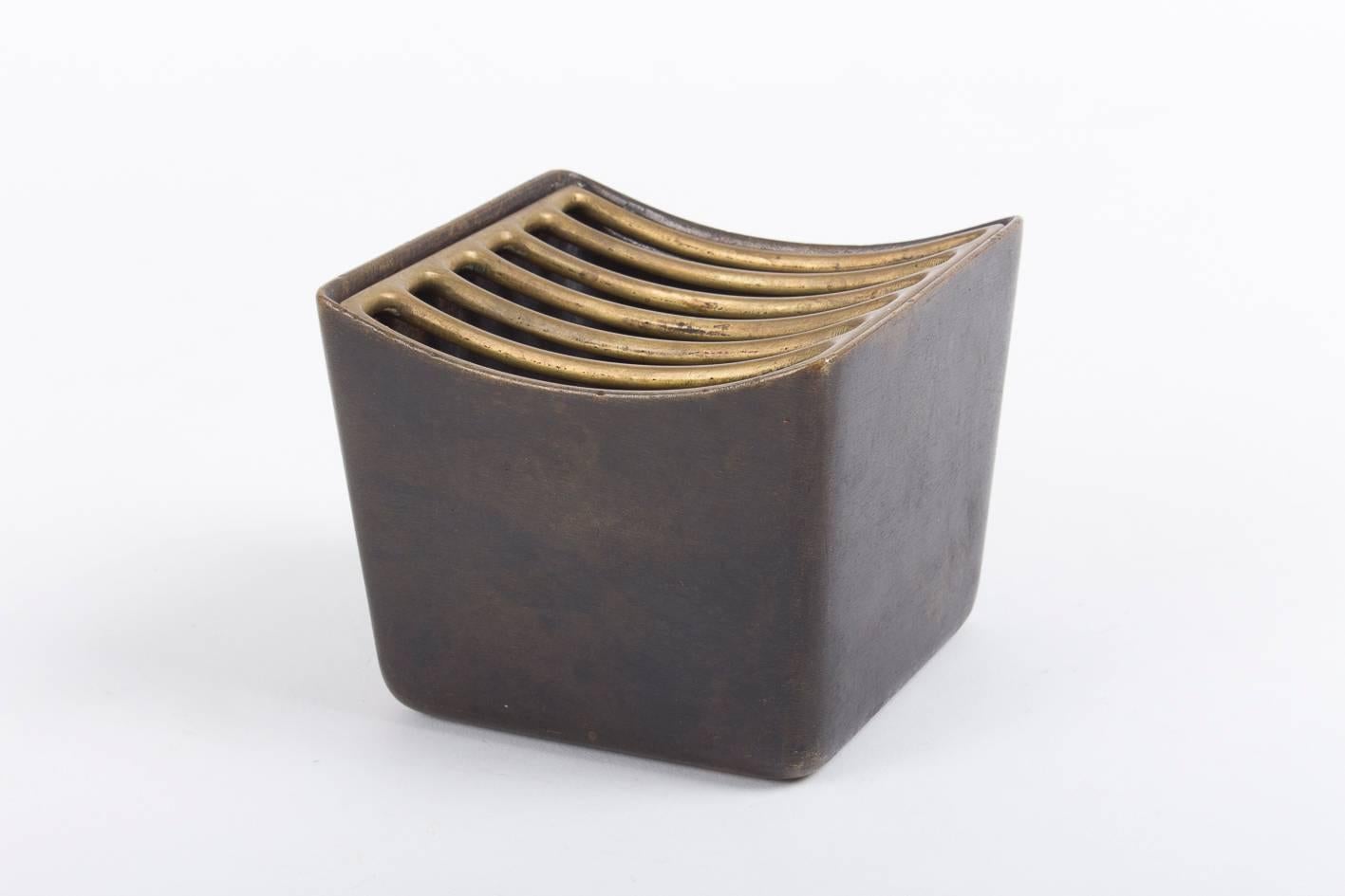 Its simple forms and carefully designed details make this small object a true eyecatcher. Manufactured in massive brass, the corpus patinated, the grill with an aged surface.

On the bottom the three marks of the Hagenauer workshop 'Hagenauer