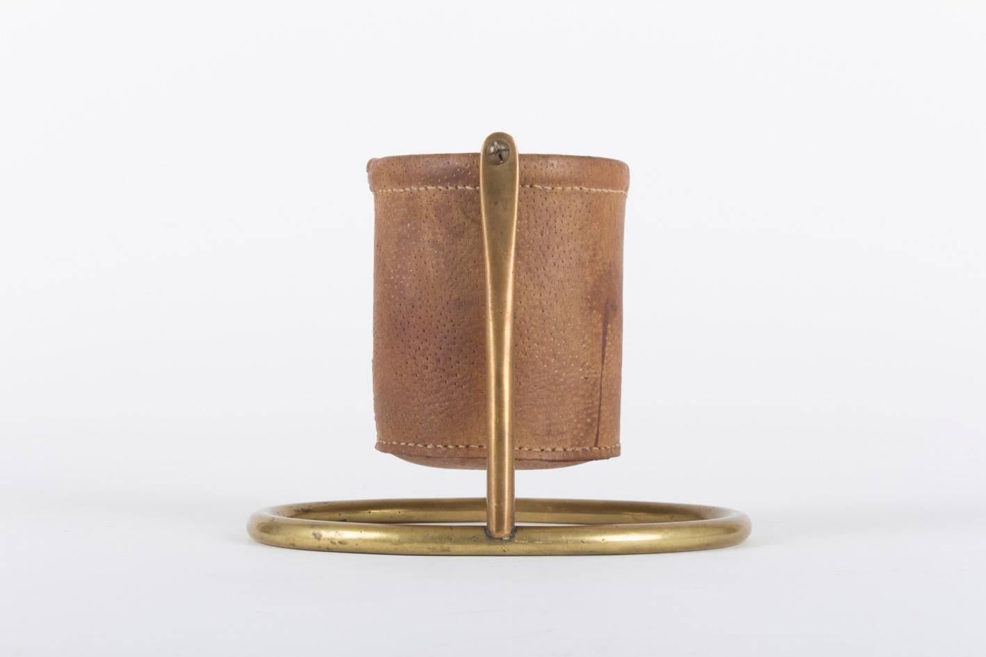 A quite rare bar accessory by the famous workshop of Carl Auböck, Vienna.
Made from solid brass and punctuated leather. Interesting are the manneristic and deeply cut screws as well as the decorative pattern of the leather yarn.

 