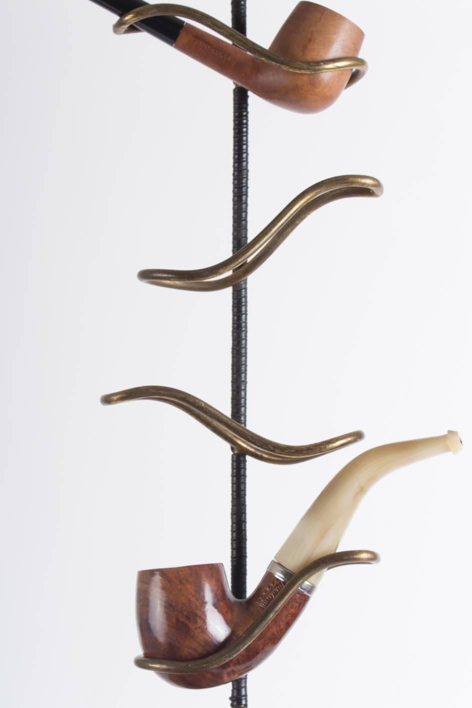 This Midcentury pipe holder is made of wrapped leather and brass with striking similarities to similar pieces by the infamous workshop of Carl Auböck in Vienna.

The pipes can be part of any purchase but are not automatically included.