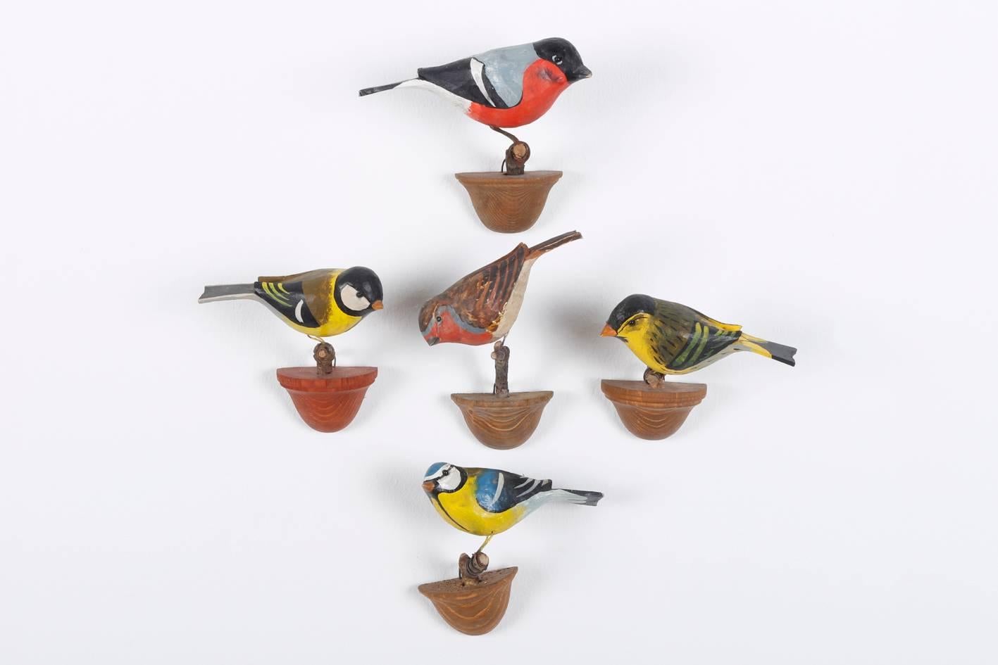 Austria early 20th century, beautifully carved wood birds, mainly oscine
birds, mounted on wooden stands for hanging.

The tradition of these in Austria called Viechtauer birds goes back to the 19th century when unemployment was increasing in