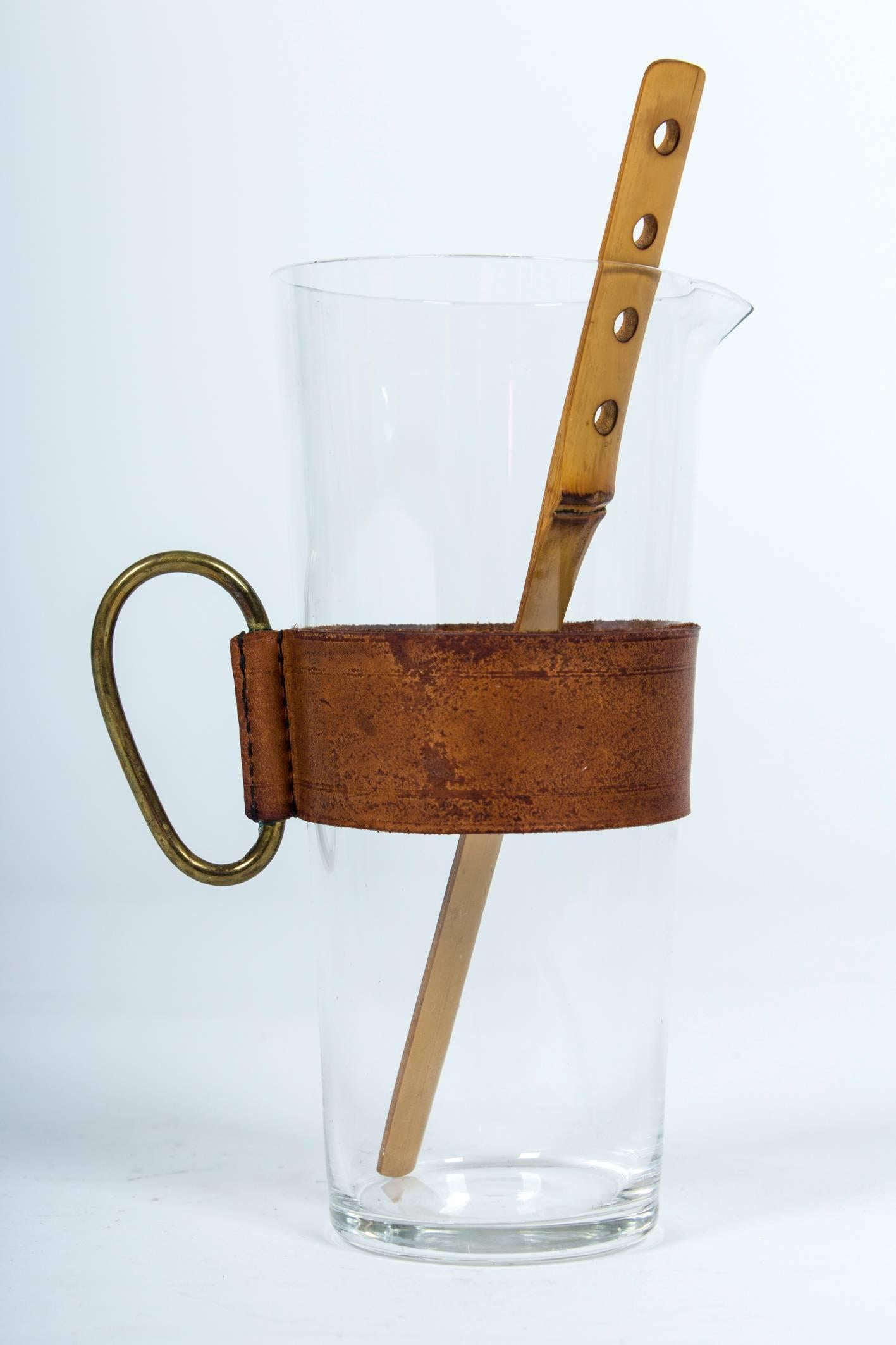 Glass, leather, brass hand with the original bamboo stirrer. Excellent condition.