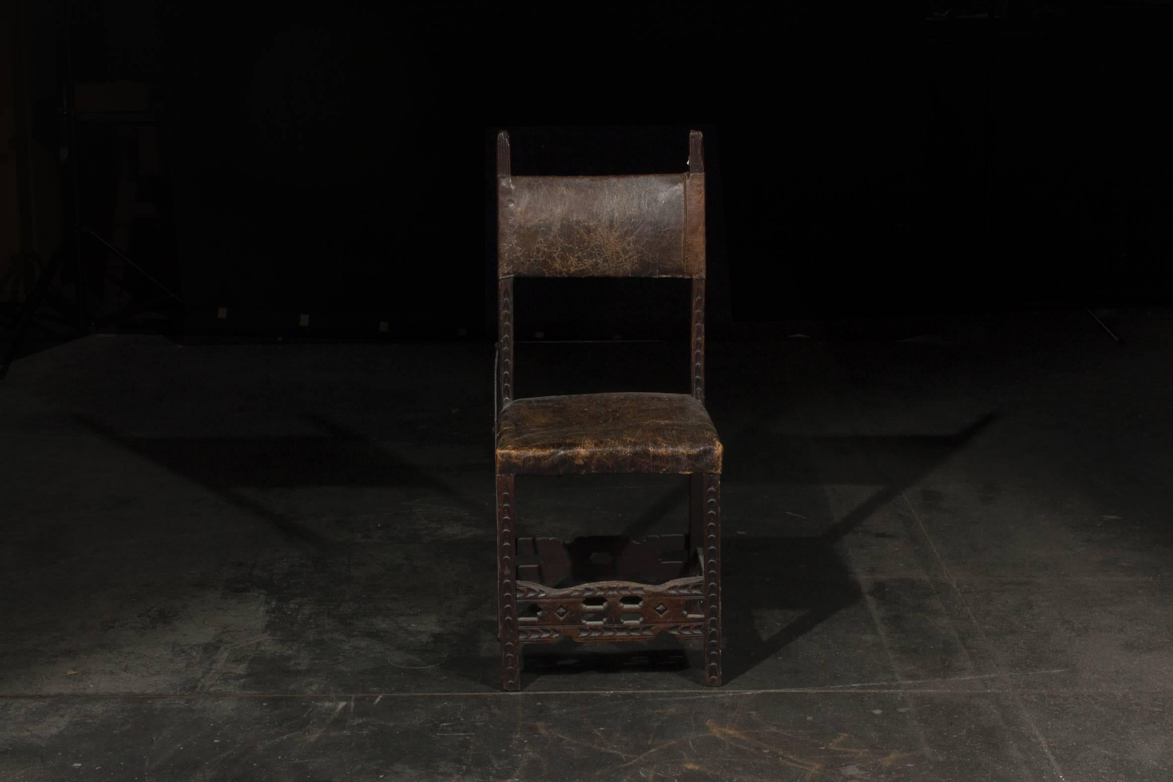 This 17th century Renaissance chair is made of carved wood and an original leather upholstery. 

On one side its stability was increased by a wrought iron part. 

Original unrestored condition. 