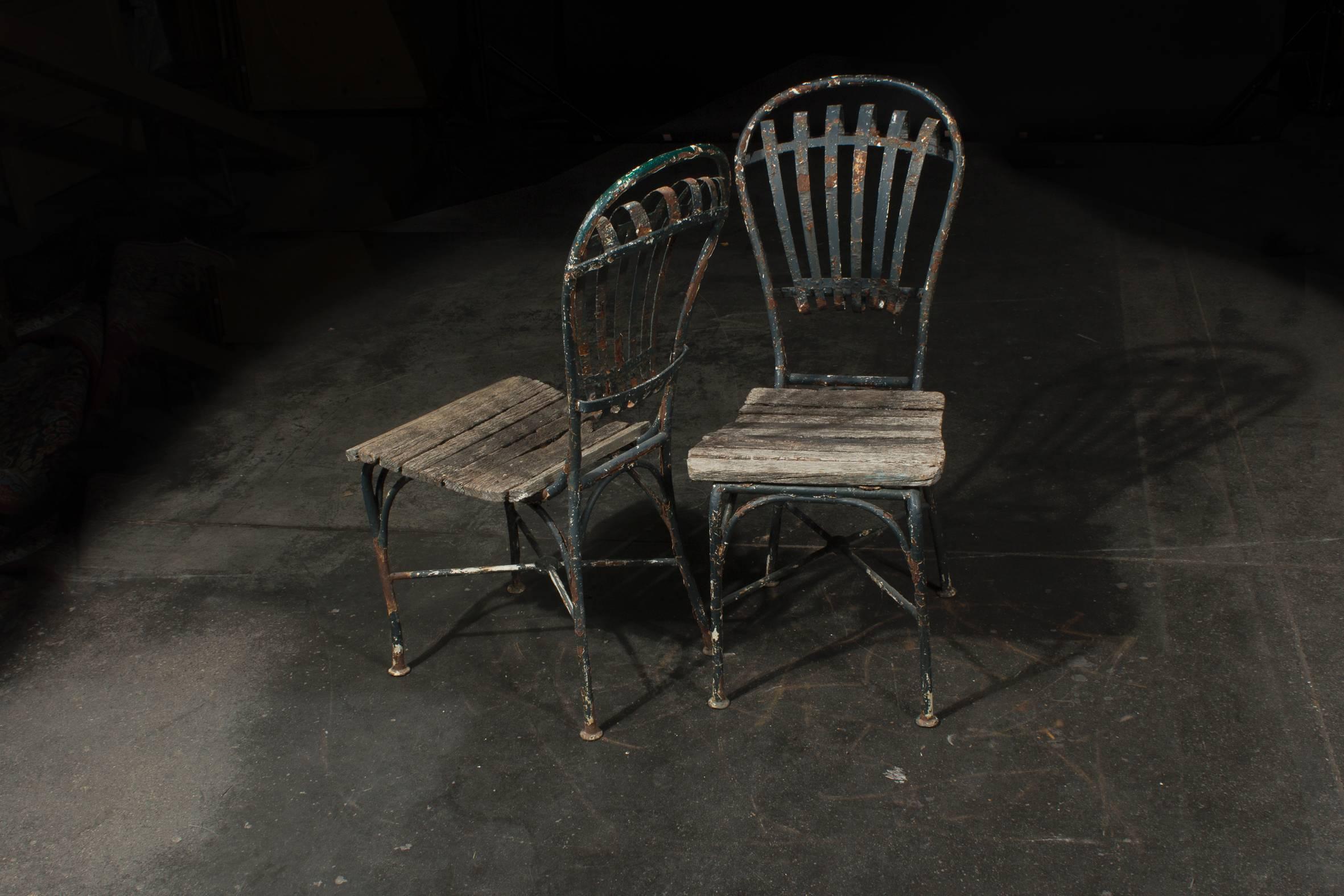 The two garden chairs can approximately be dated around 1860.
By their style an either a French or Bohemian origin seems likely. 

Made of iron and wood. 
As shown on the images in beautiful aged condition.