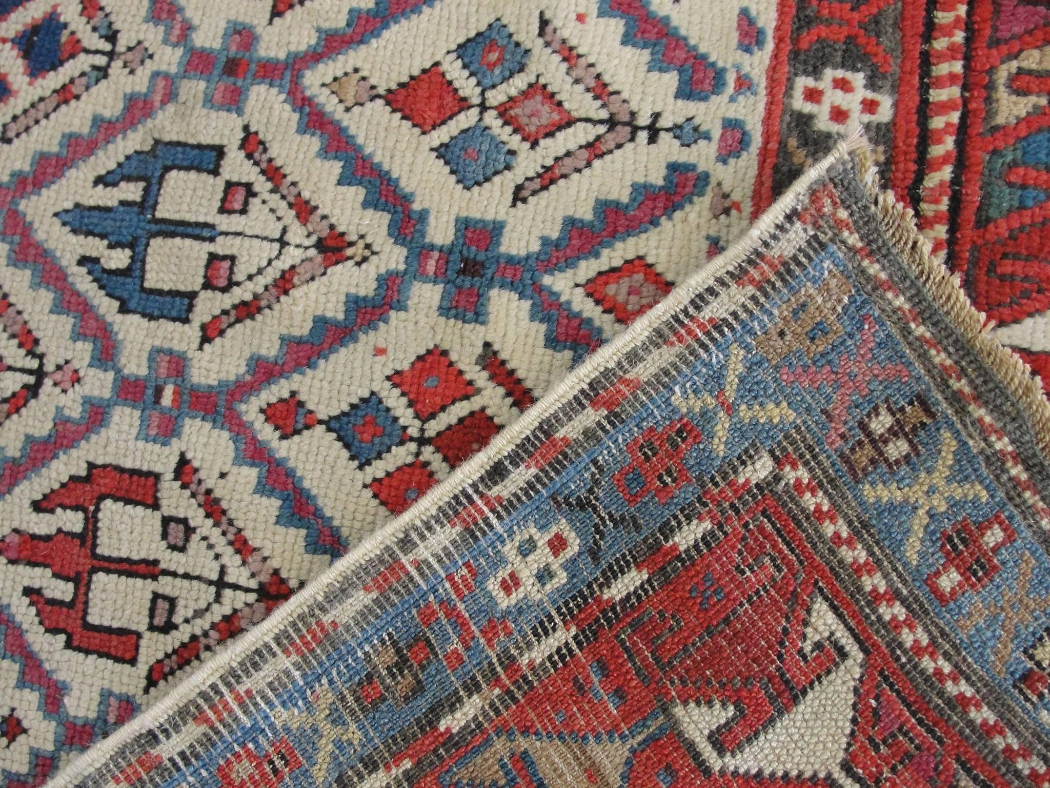 Antique Shirvan Prayer rug with multi-color motives on white background field.
The historic Khanate or administrative district of Shirvan produced many highly decorative antique rugs that have a formality and stylistic complexity that is found in