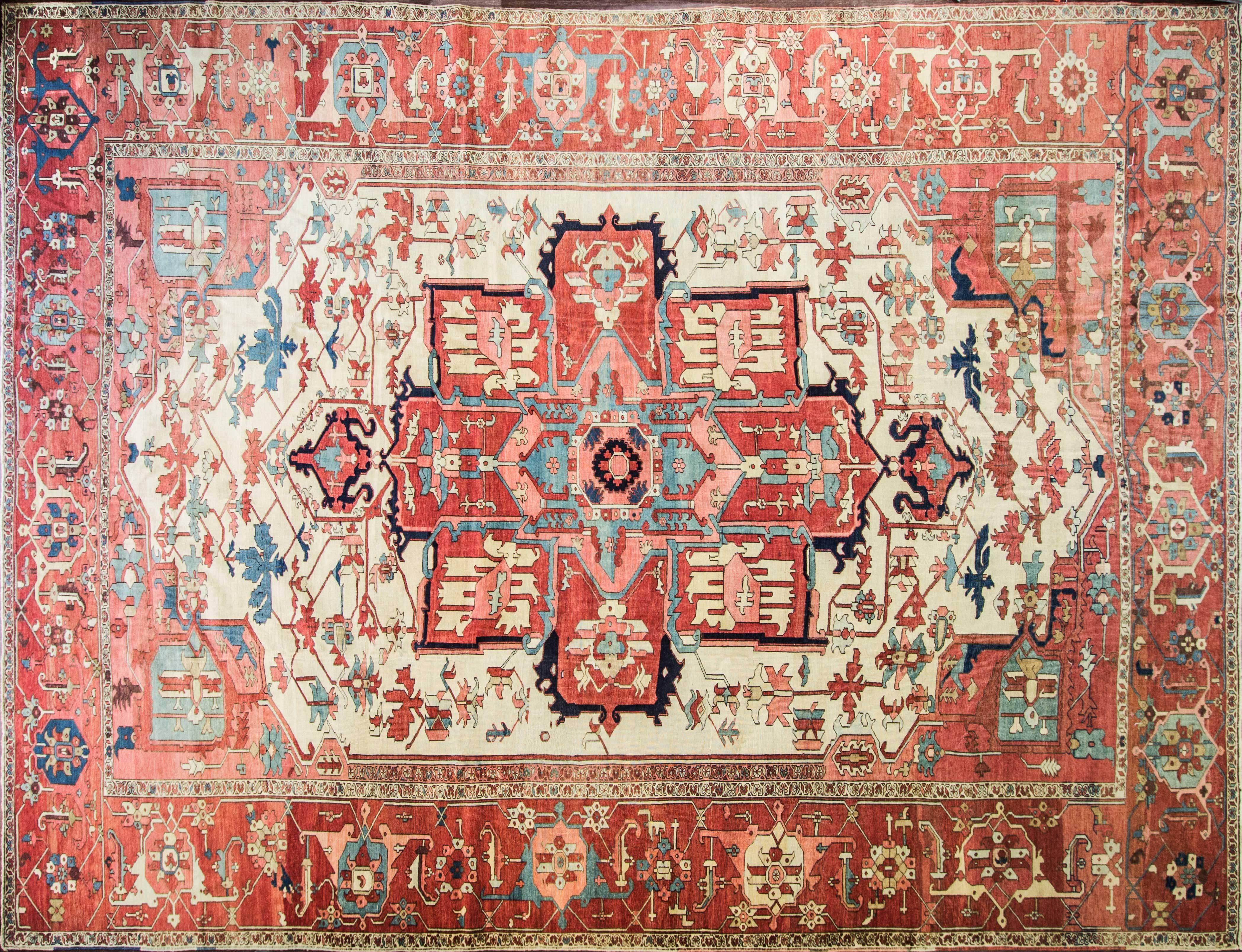 Large size antique Persian Serapi rug, Persia, circa late 19th century. This remarkable and artistic antique rug, showcases an ornate, multicolored central design. At the heart of the antique Persian Heriz Serapi rug, a many-petaled flower is
