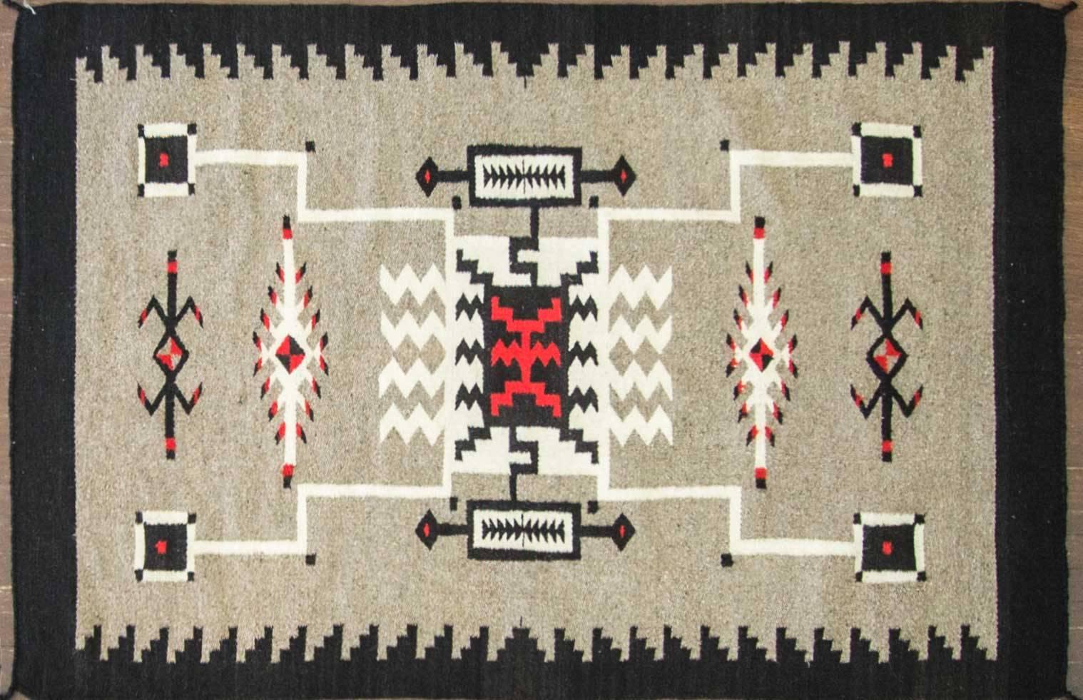 Two grey hills arose as a regional style center during the 1940s. These Navajo Indian rugs are distinguished by the bordered central lozenge design, and use of primarily undyed wools in tan, gray, brown, white and deep black. Borders are often