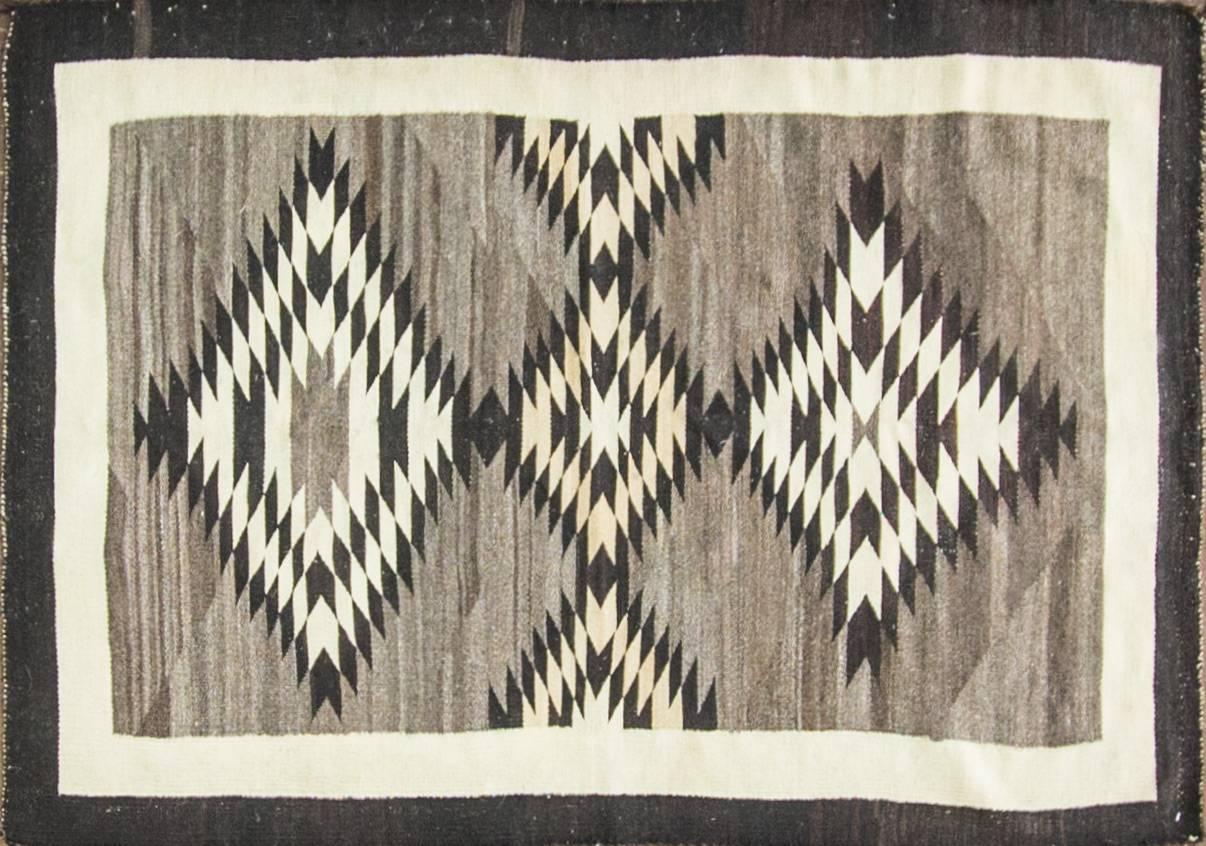 This is a really majestic, old style two grey hills weaving, circa 1920s-1930s. The rug is made completely of hand-shorn wool and is hand carded and spun as well. The colors are completely natural. This is a heavy well-made weaving that has seen