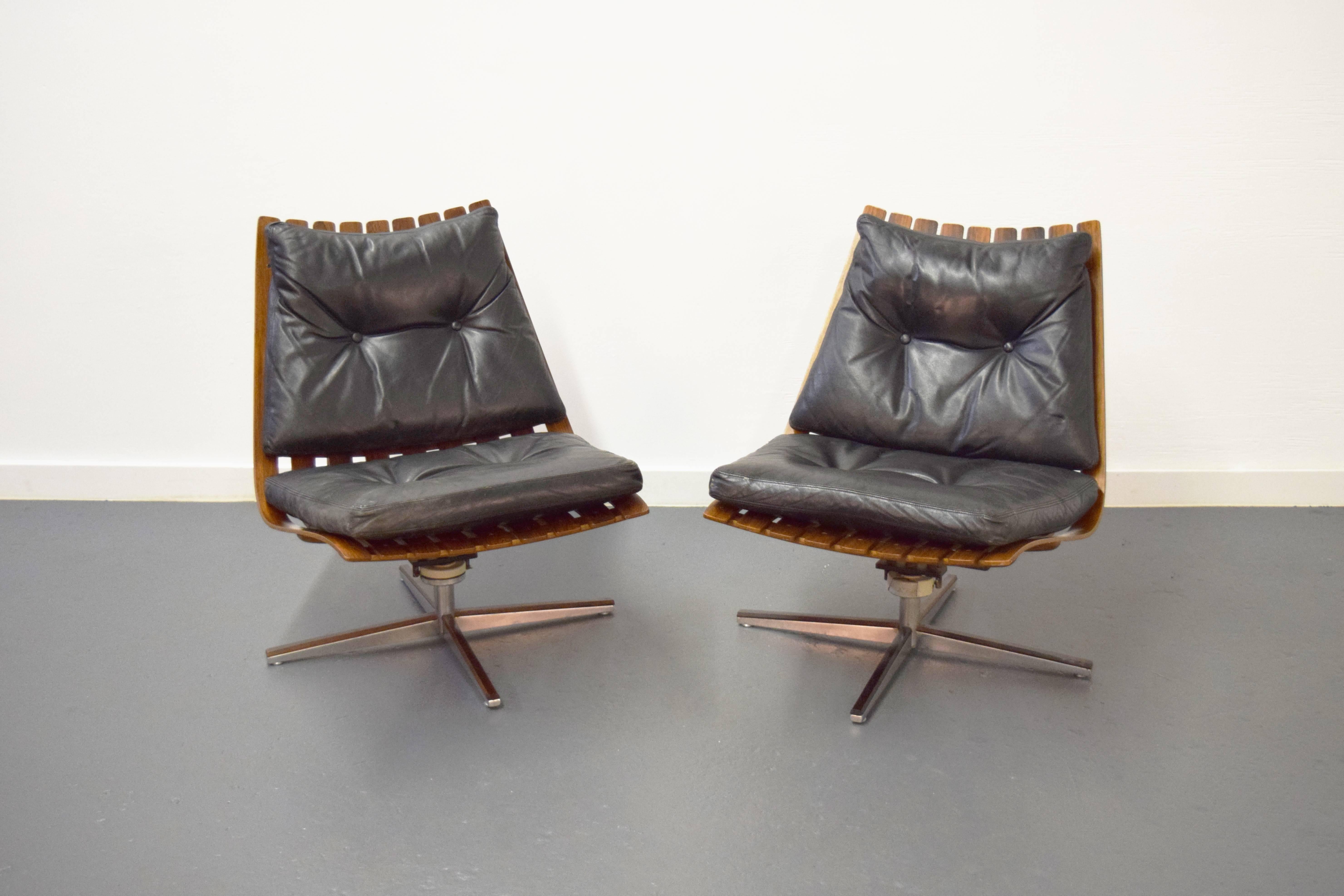 Pair of Hans Brattrud rosewood swivel lounge chairs. Chairs have original black leather cushions.
