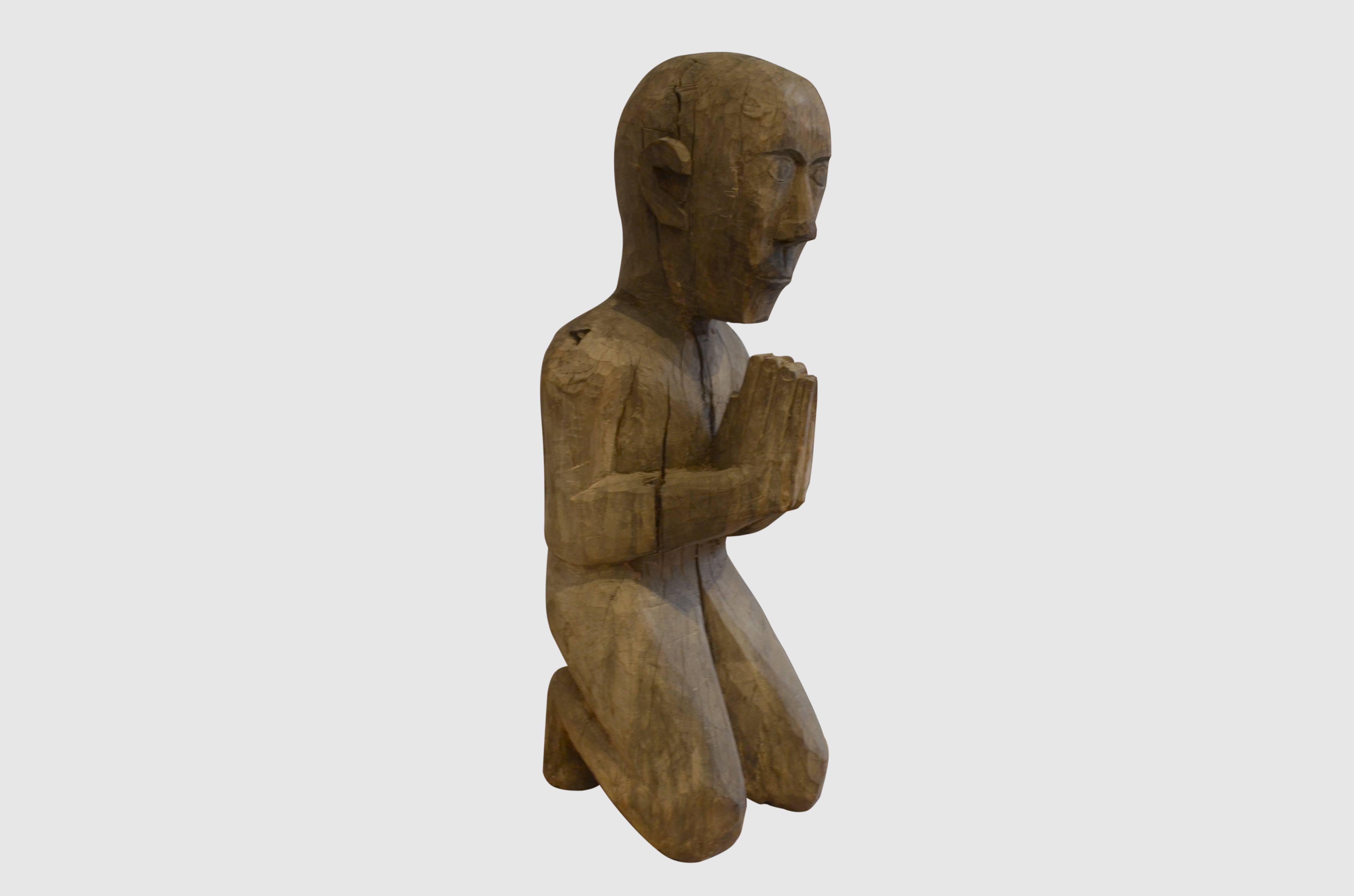 Antique Primitive man from Sumatra praying. Carved from a single piece of aged teak wood.