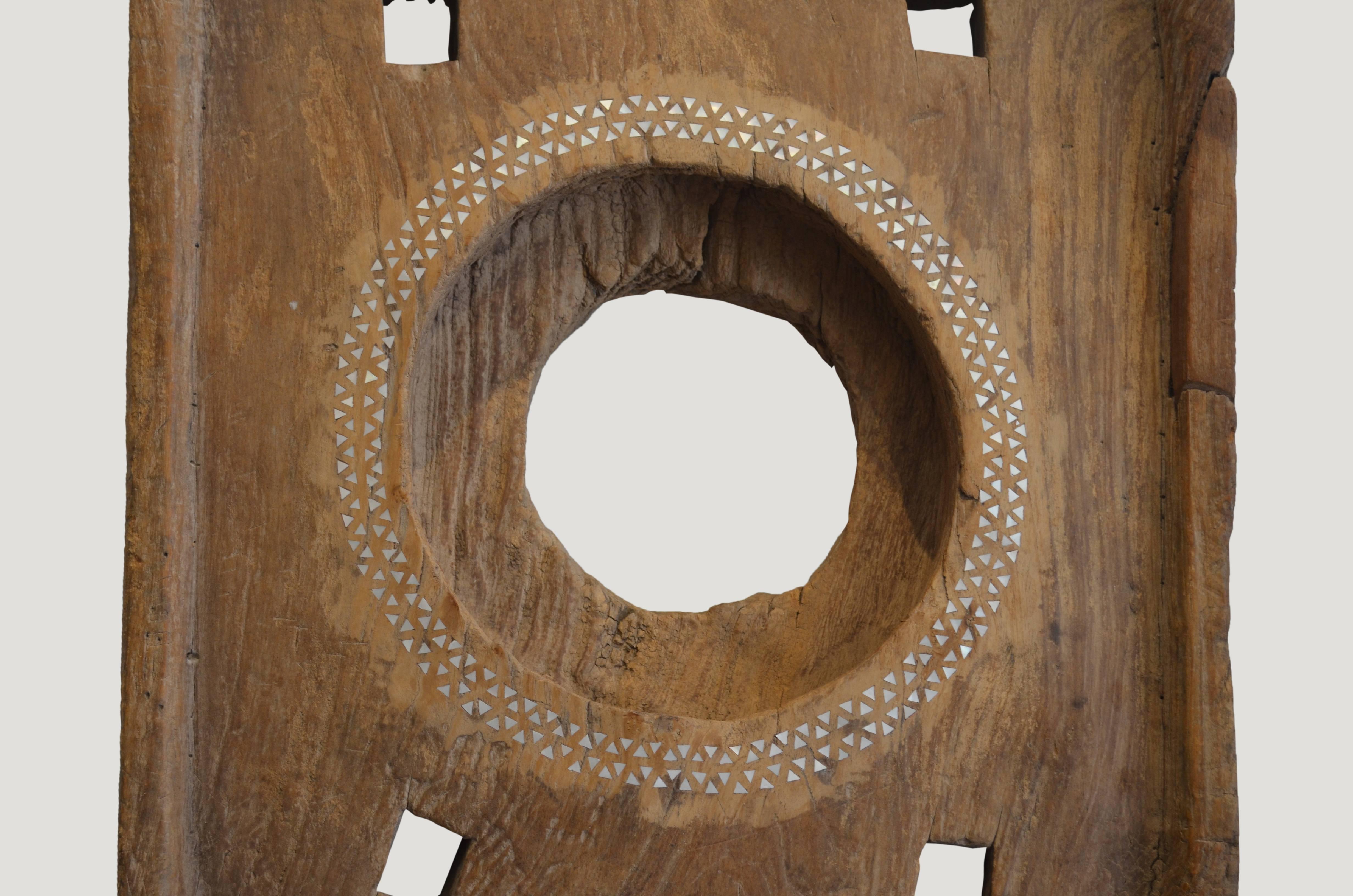Antique rice pounder top made from aged teak. Hand cut pieces of mother of pearl shell are carefully cut  into the teak wood. Various sizes available in partial or full shell inlay. Great as an art installation grouped, or as a single